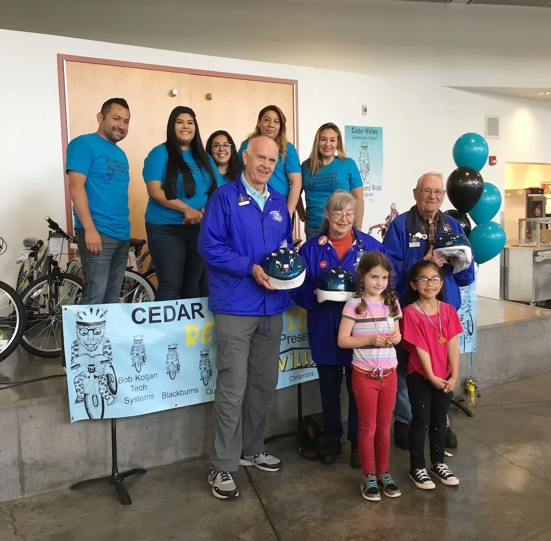 Edmonds Kiwanis members distributing free helmets to Cedar Valley Community School children