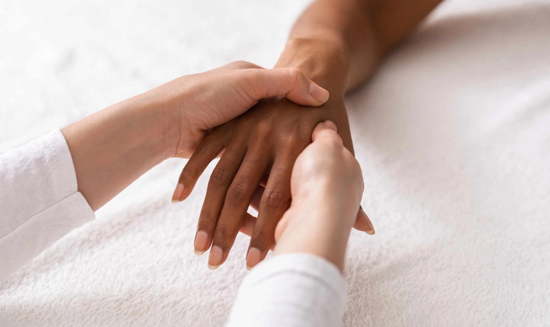 Close up of an acupuncturist taking the pulse of a patient.