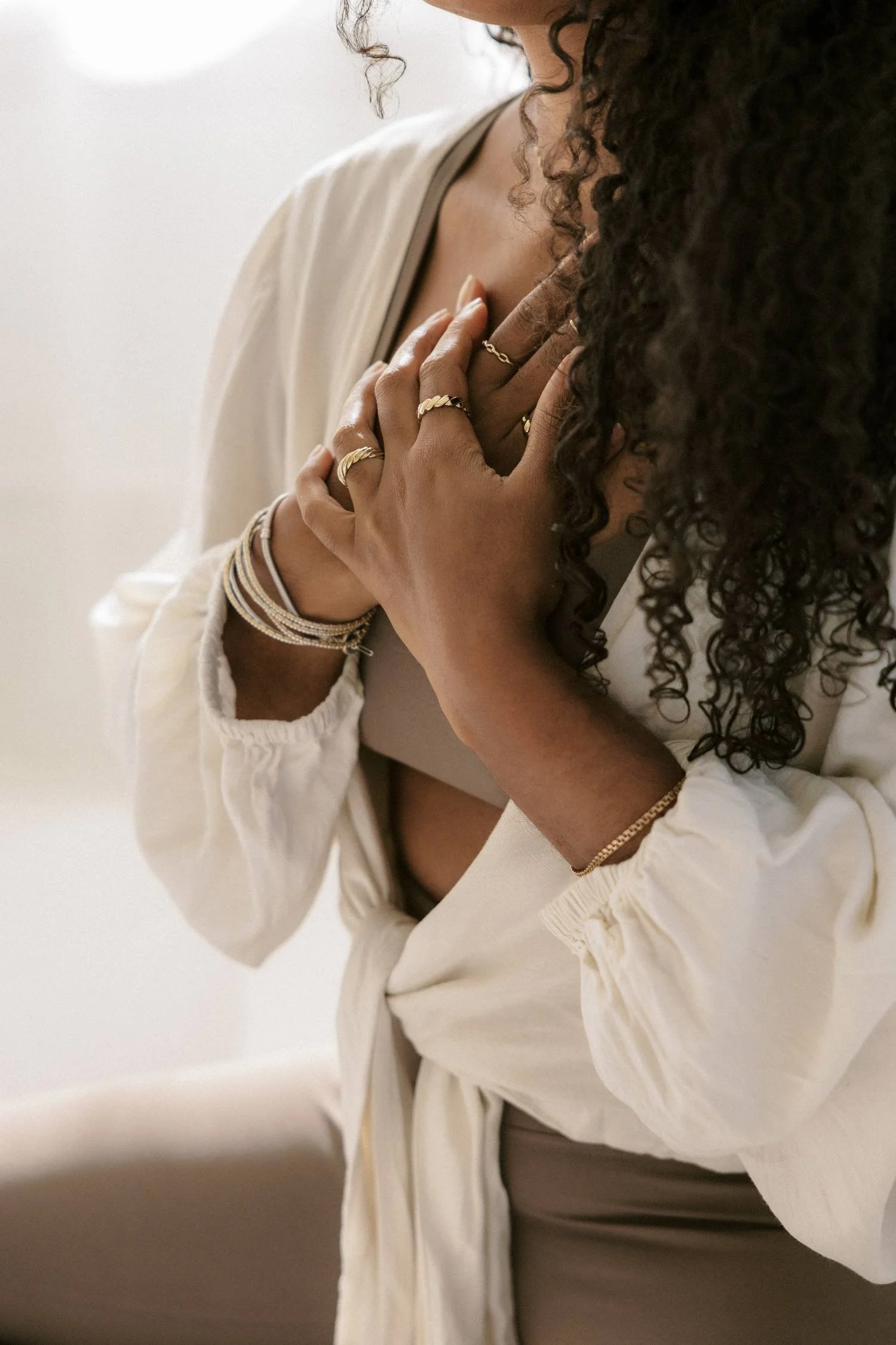 Woman resting her hands gently against her chest, reflecting the calm of preconception support in San Diego