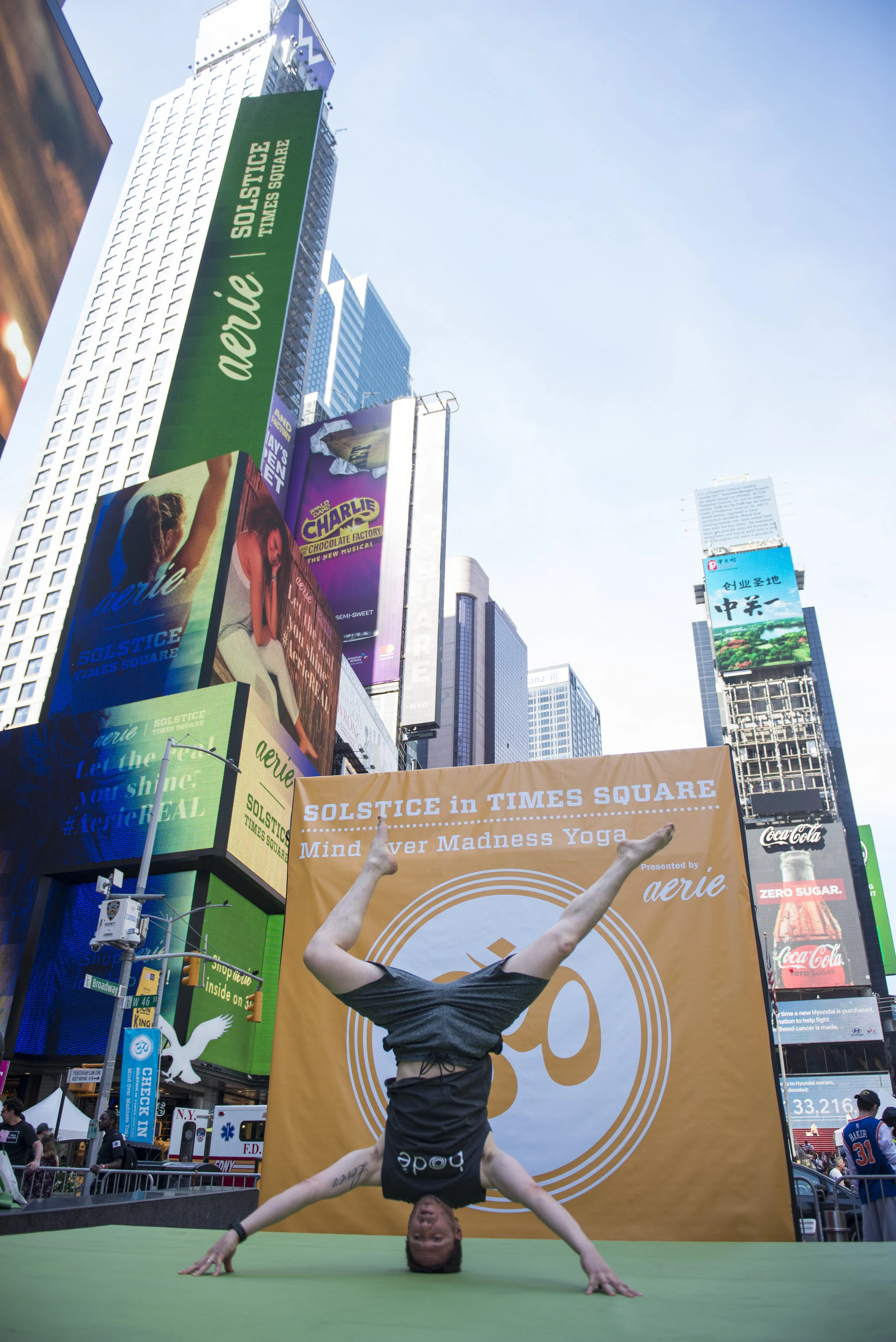  Omri Kleinberger participates in Solstice in the Times Square: Mind Over Madness Yoga event on Thursday, June 21, 2018 in Times Square. Kleinsberger describes this pose as a "headstand with a little fun." 