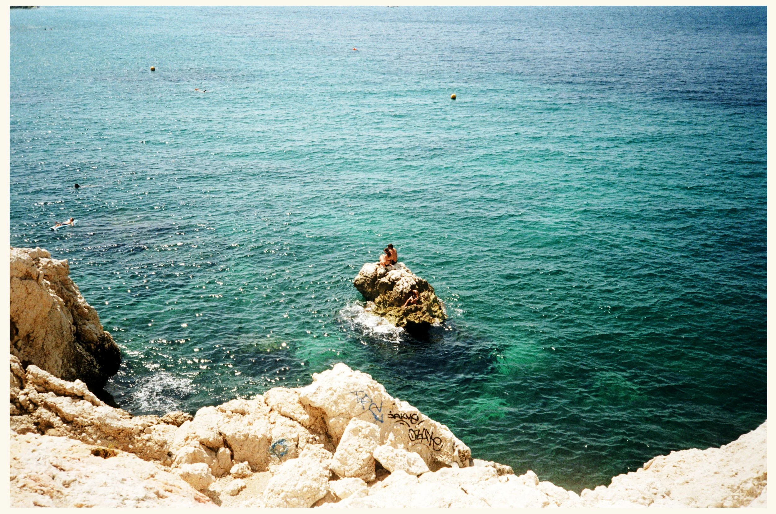 A young couple sits on the Marseille Rocks