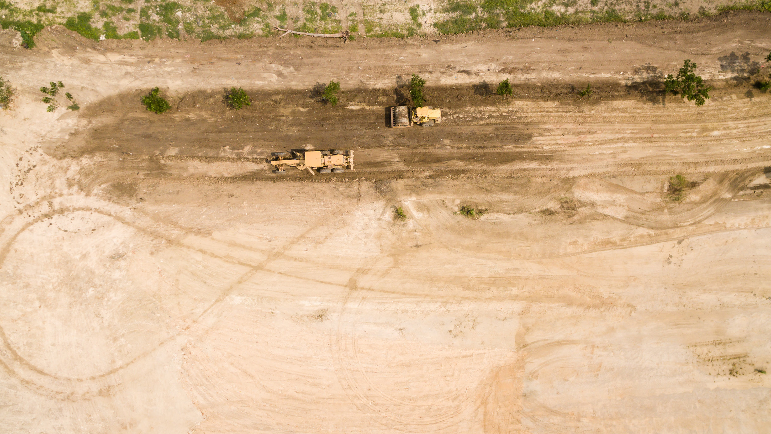 aerial-view-grader-working-at-construction-site-673297788_3840x2160.jpeg