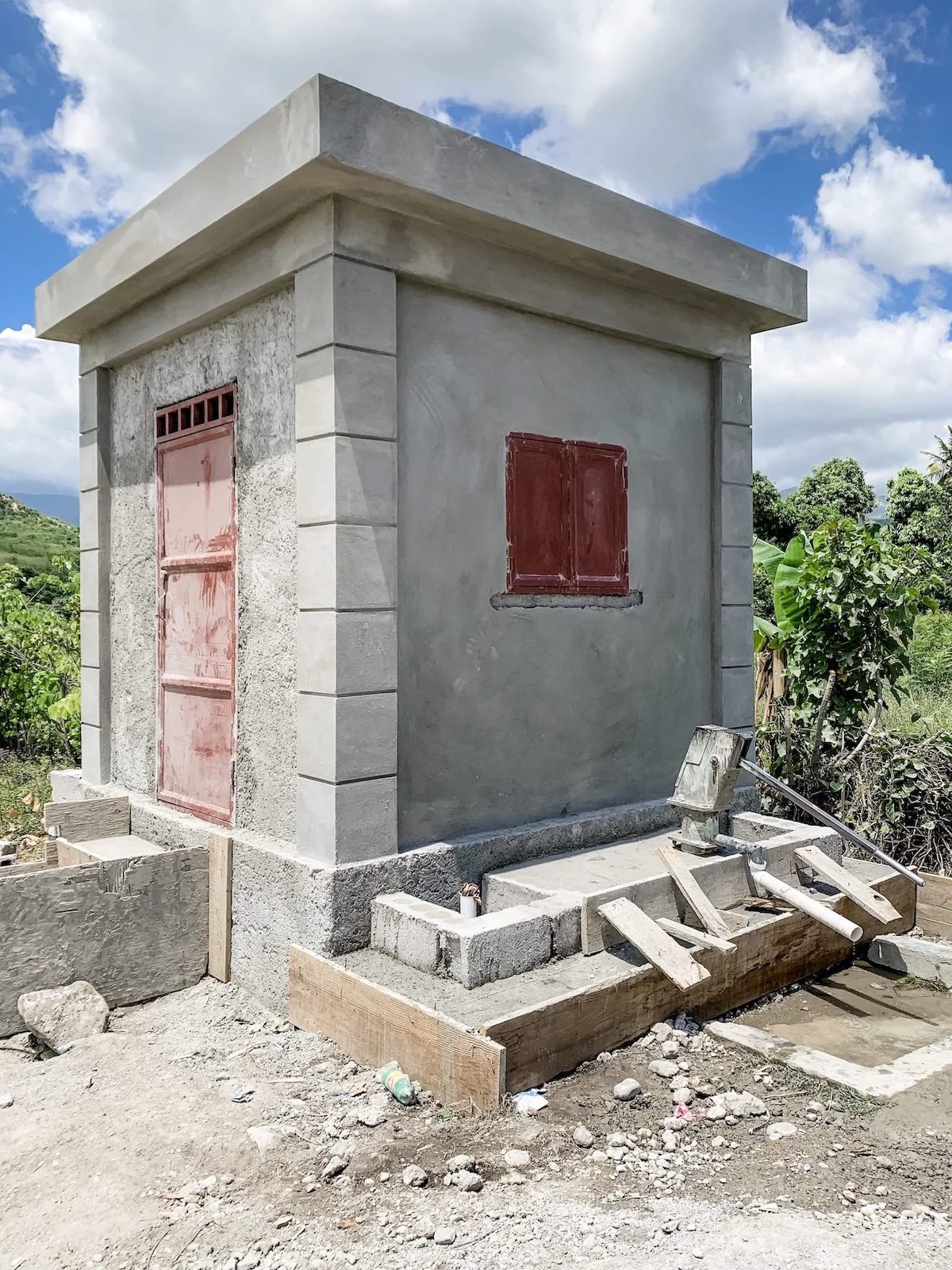 THE WATER WELL IN LA BEYI! YOU CAN SEE A HAND PUMP WELL AT THE FRONT OF THE BUILDING, WHICH THEY DESCRIBED CAN BE USED FOR CLEANING PURPOSES. INSIDE, THERE WILL BE A MORE SOPHISTICATED SYSTEM THAT WILL FILTER AND CHLORINATE WATER FOR DRINKING! WATCH THIS VIDEO TO SEE HOW IT WILL WORK!