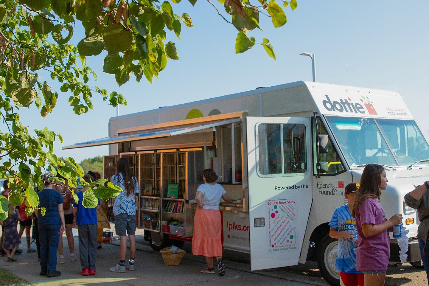 @lawrencelibrary mobile library moments 🤍🚛🫧

Image 1: Dottie is parked in front of Billy Mills Middle School, proudly displaying books.

Image 2: A Library staff member hands out prizes to two children. Bubbles are highlighted by the sun.

Image 3