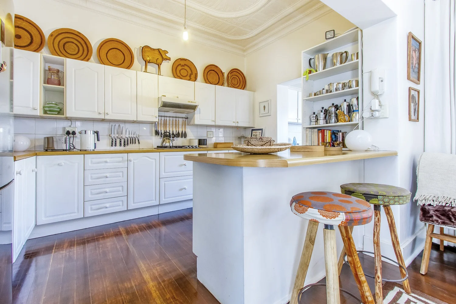 Kitchen with breakfast counter, bar stools and pressed ceiling