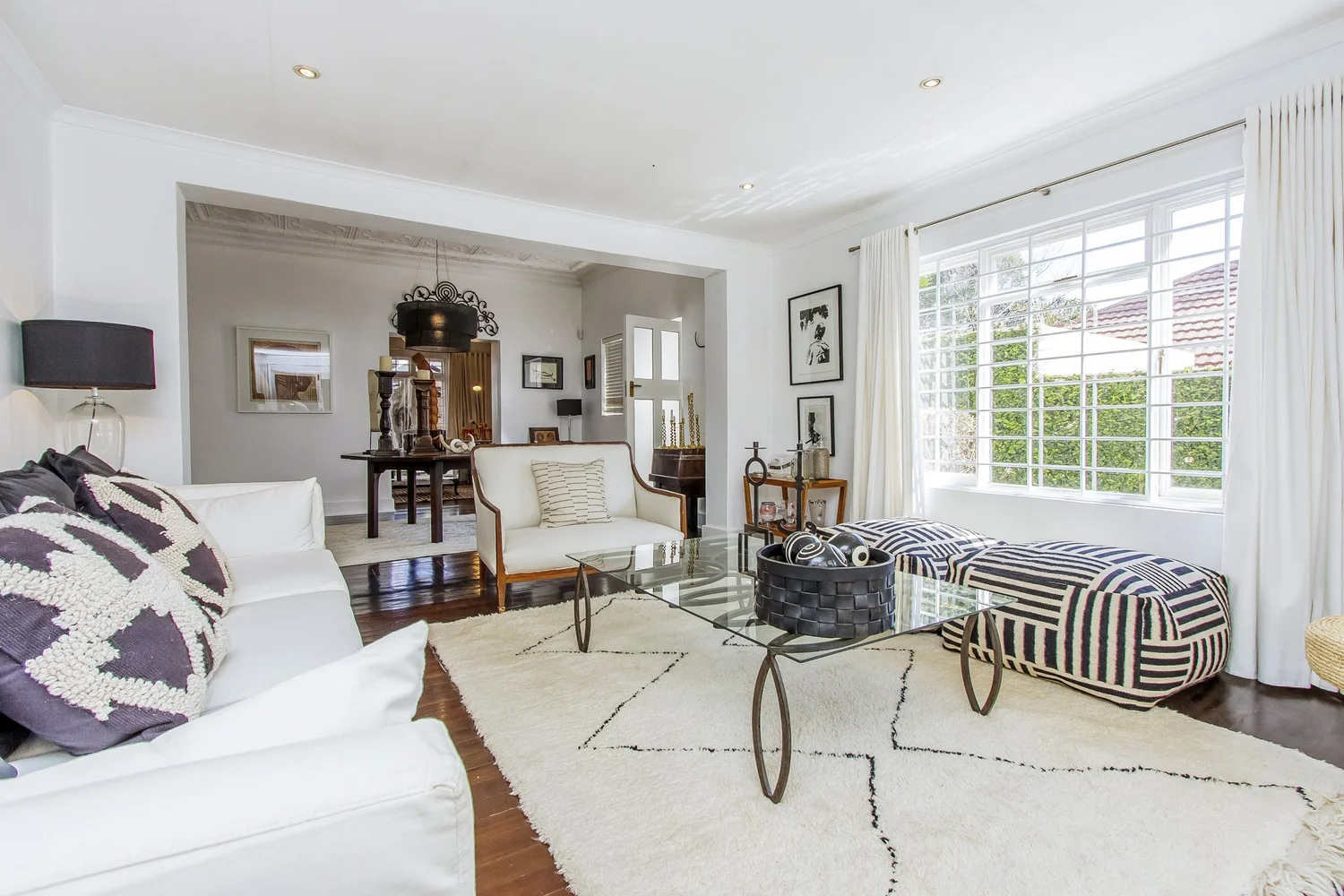 Light-filled lounge with white sofas and a patterned rug