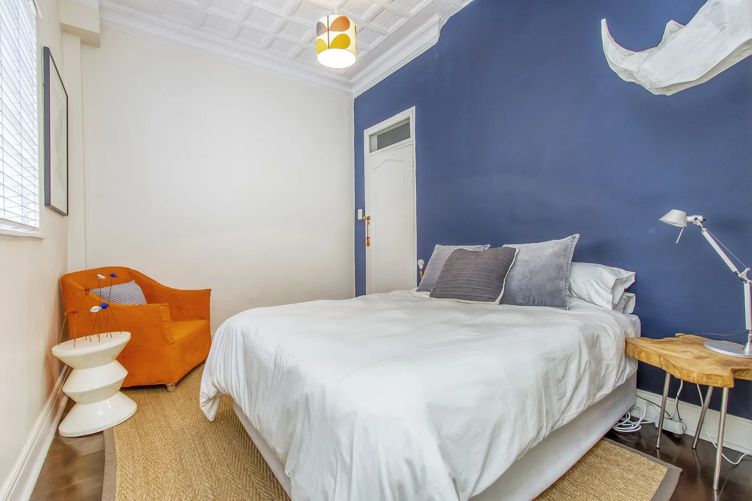 Bedroom with deep blue feature wall and pressed ceiling