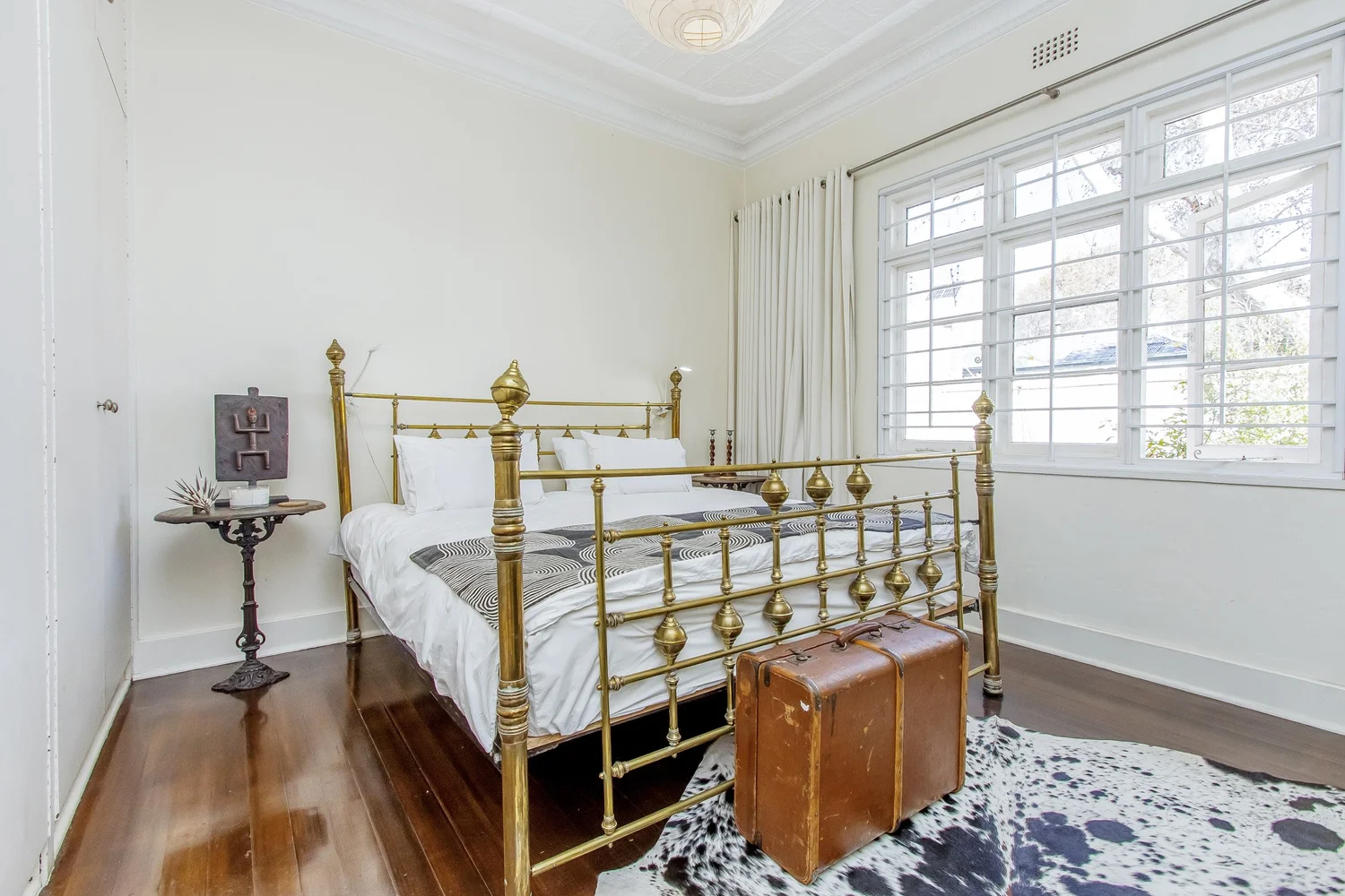 Bedroom with antique brass bed and large windows