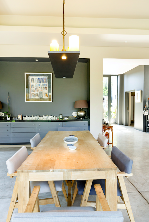 Solid timber dining table beneath a candle pendant light