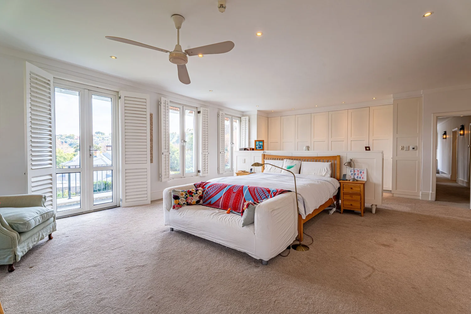Main suite with shuttered doors opening onto a private balcony