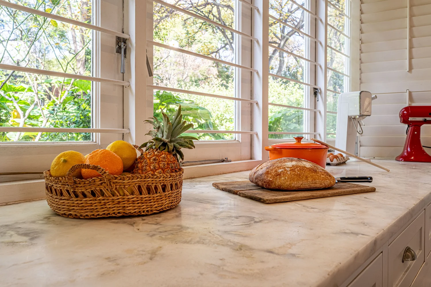 Marble kitchen countertop beneath windows onto the garden