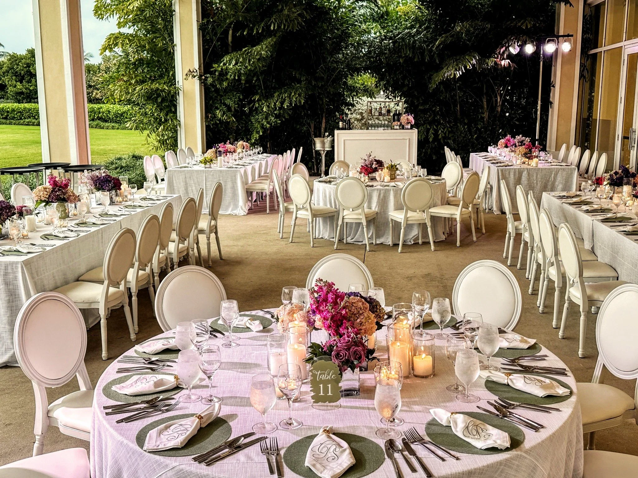 As the sun dipped over the Baha Mar lawn, the celebration settled into something beautifully understated.

White linen, sage accents, tropical blooms, and a seating display framed in roses &mdash; pinks, reds, and purples welcoming each guest with a 
