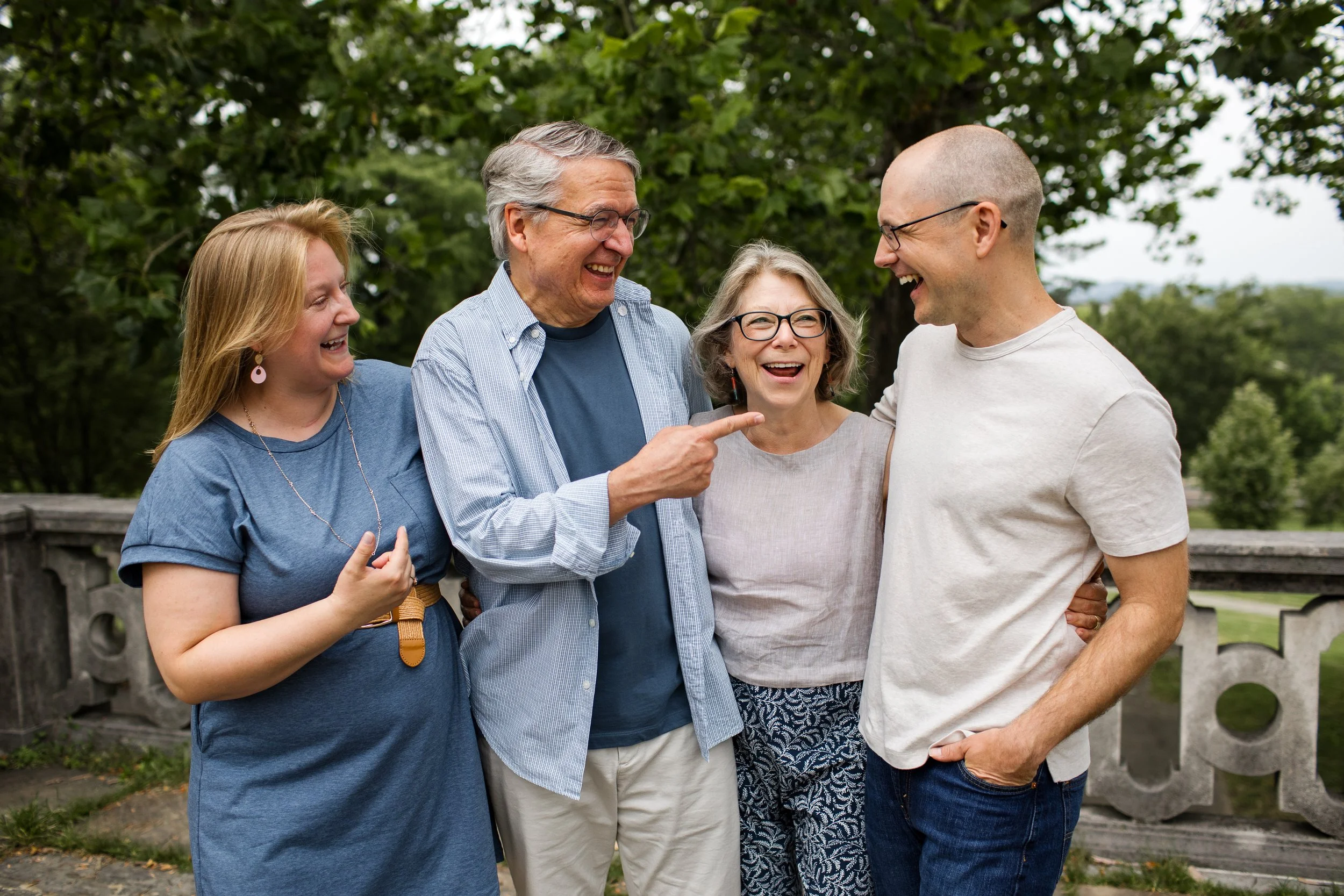 Parents converse and smile with their adult children during an extended family photo session during golden hour in Pittsburgh