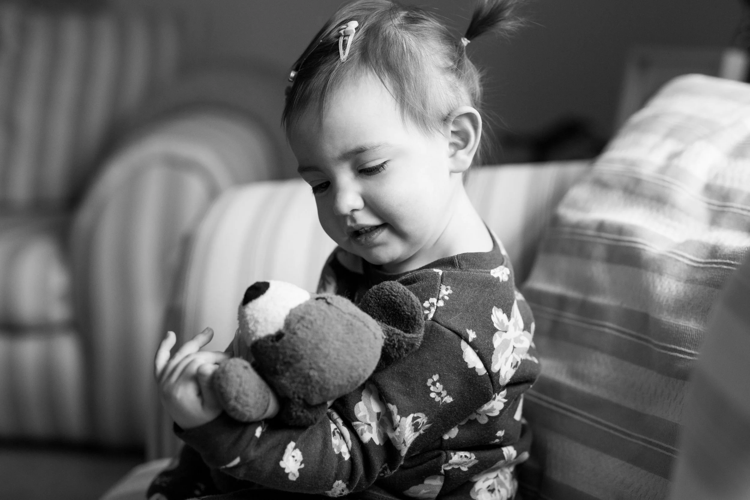 Small child holds a beloved stuffed animal toy as she sits in her home in Upper St Clair, Pittsburgh, Pennsylvania