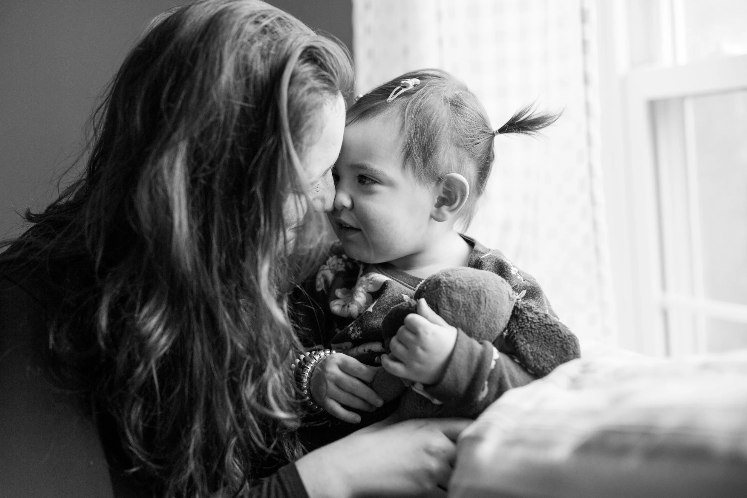 Young child and her aunt give an Eskimo kiss as they look at each other in their home in Upper St Clair