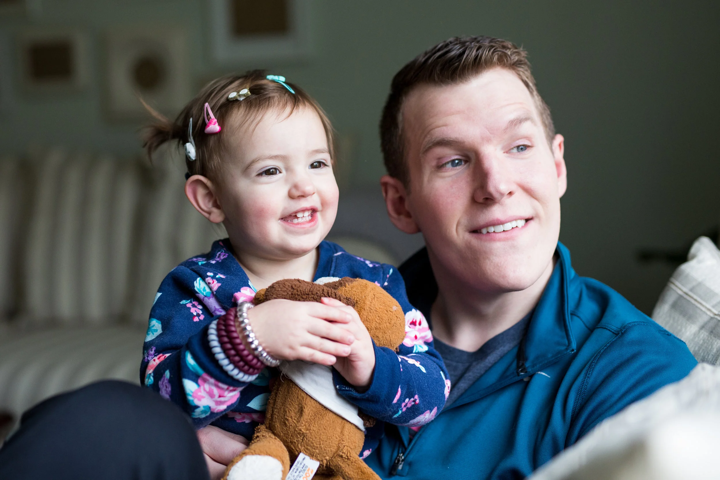 Man and child look at the window of their home in Pittsburgh, PA as beautiful natural light shines on their faces