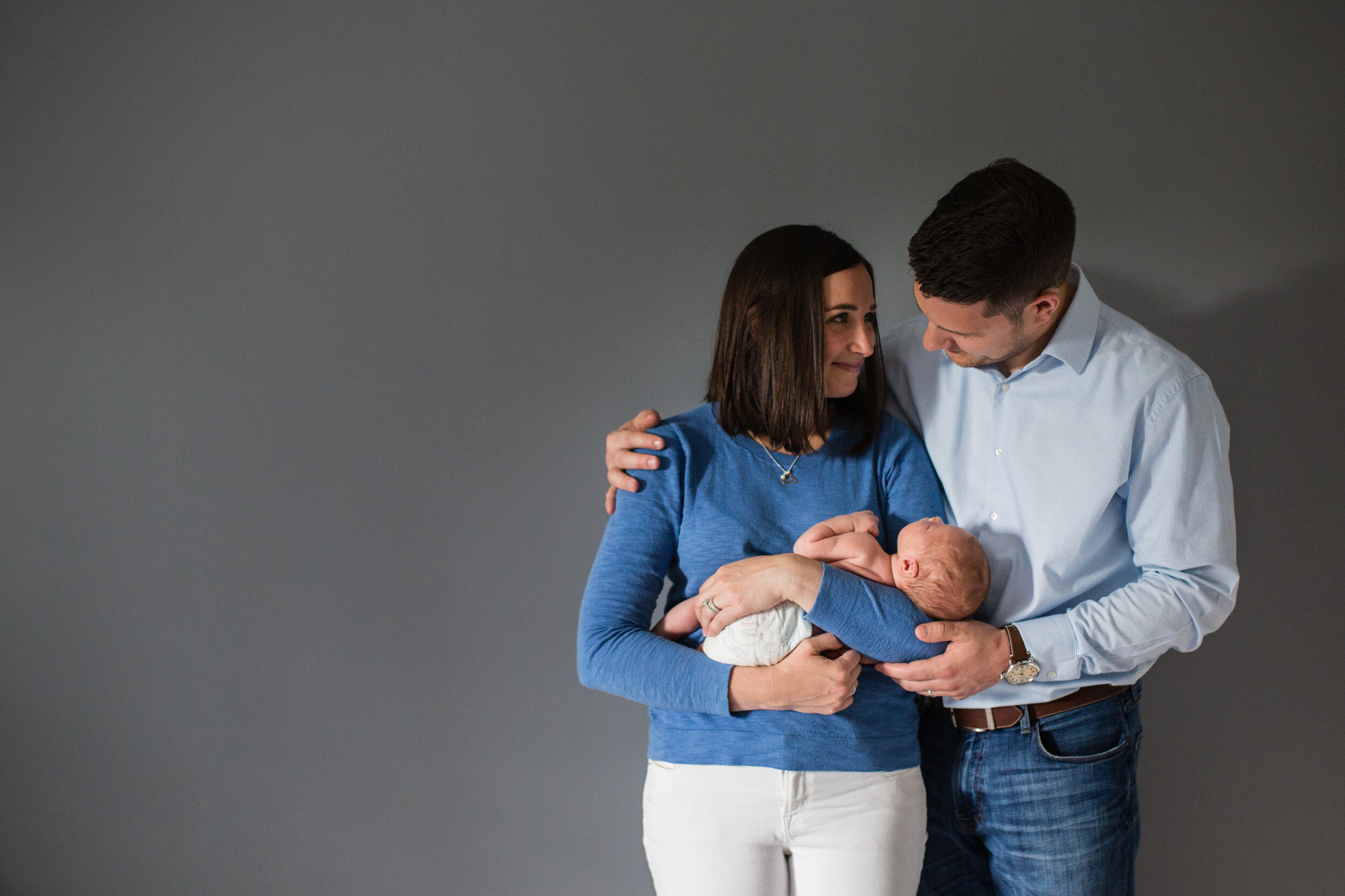 New parents hold their newly adopted baby boy. They are overjoyed with their son.