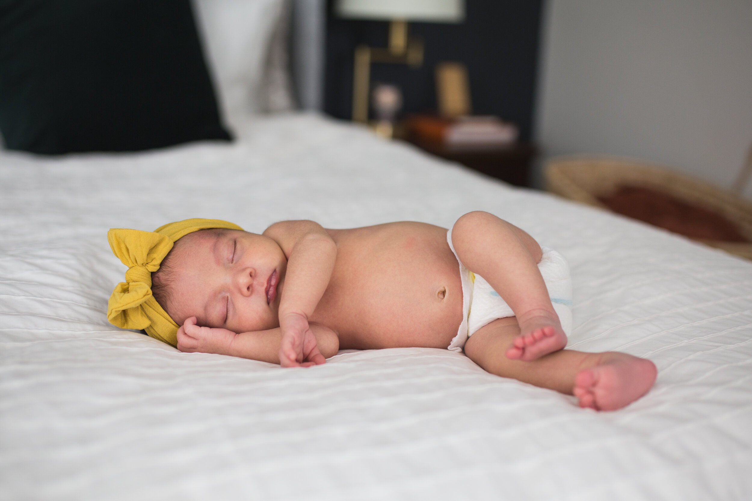 Sleeping newborn with a big bow in her Pittsburgh home