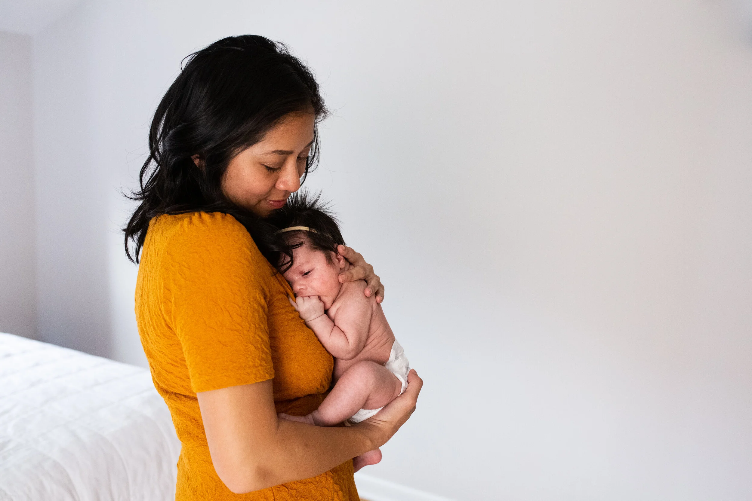 A mom holds her newborn daughter closely, in her bedroom in their Pittsburgh home.