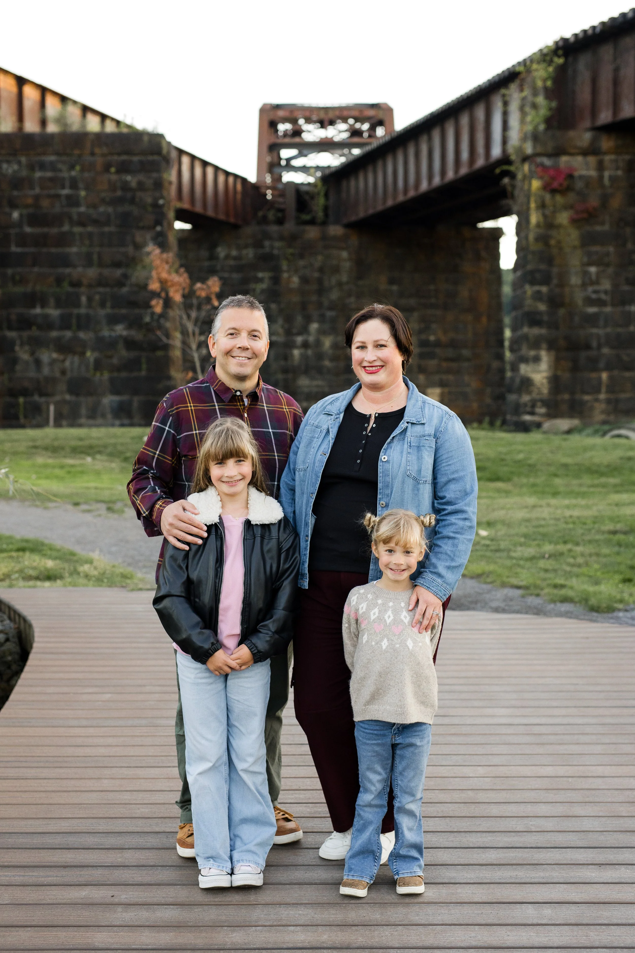 A family stands in front of historic Pittsburgh bridges in Aspinwall