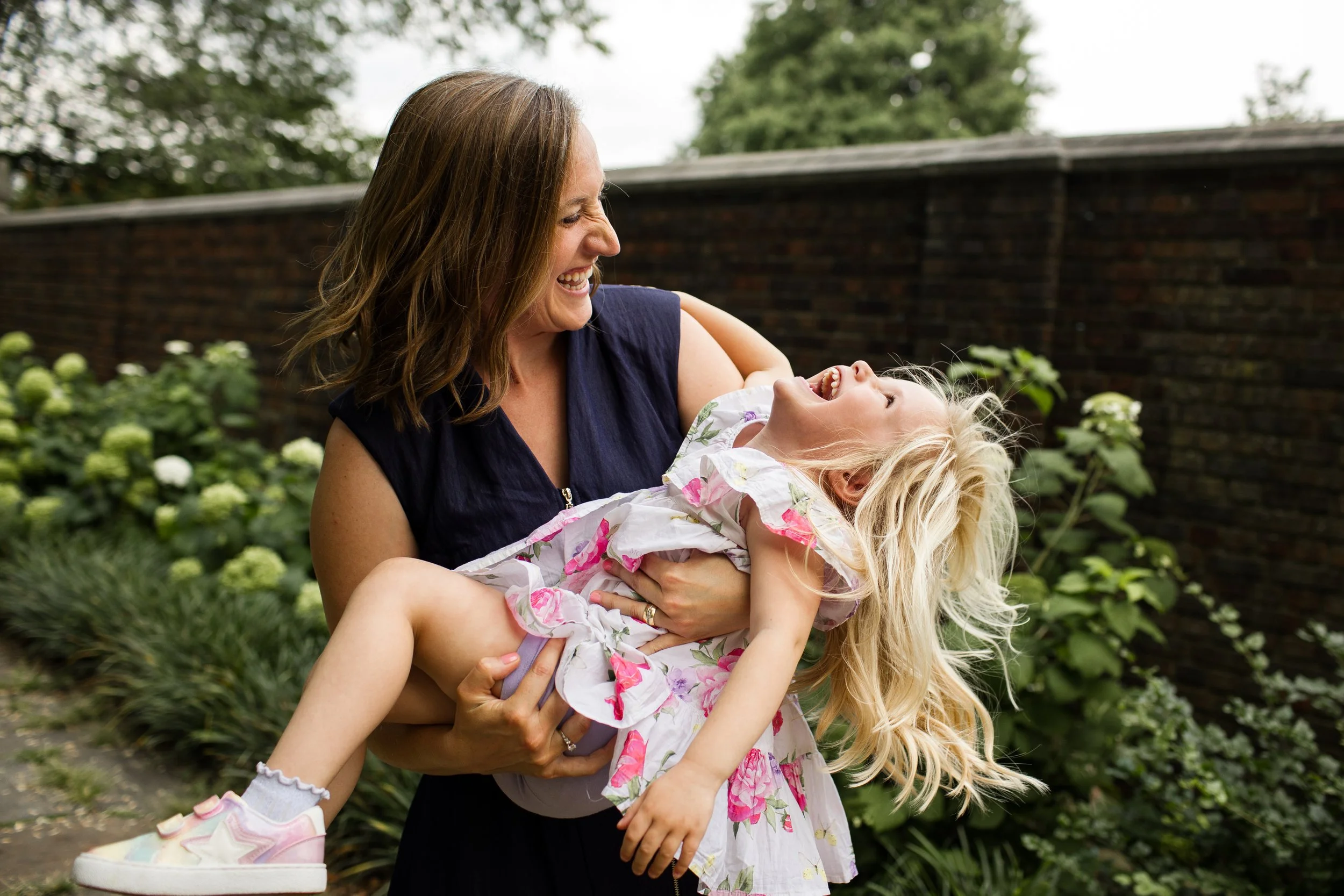 Mom holding daughter at Mellon Park, both laughing