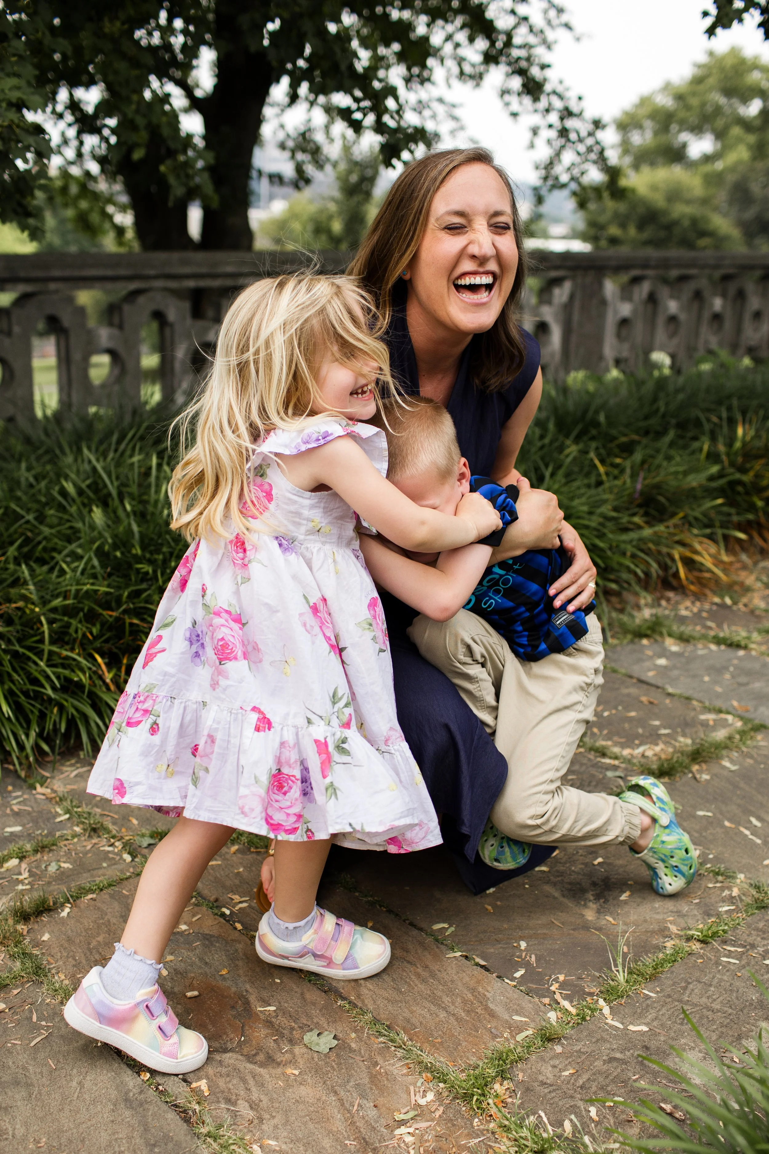 Kids run to surprise their mom with a big hug that leaves everyone laughing joyfully