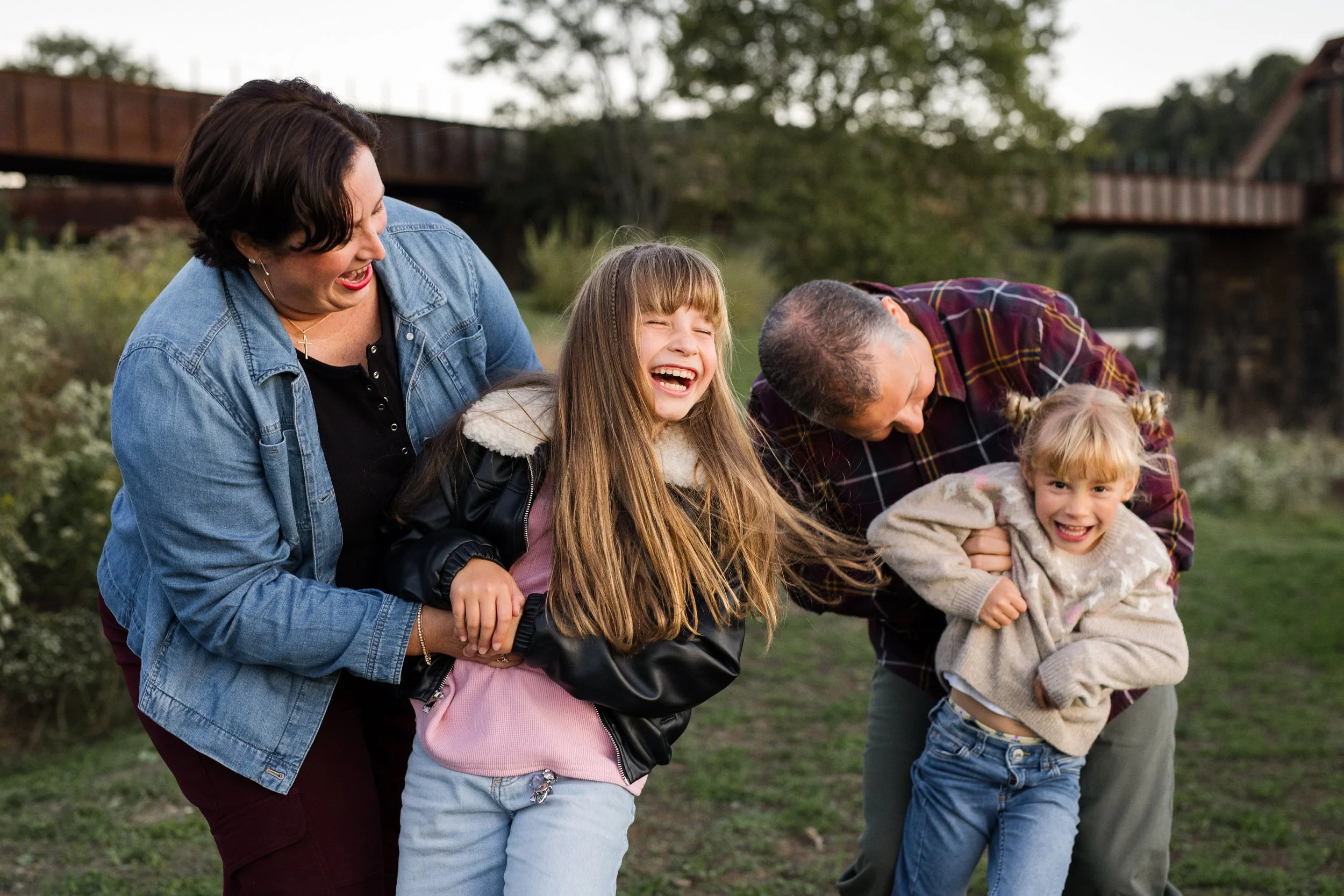 Parents tickle their daughters and everyone laughs