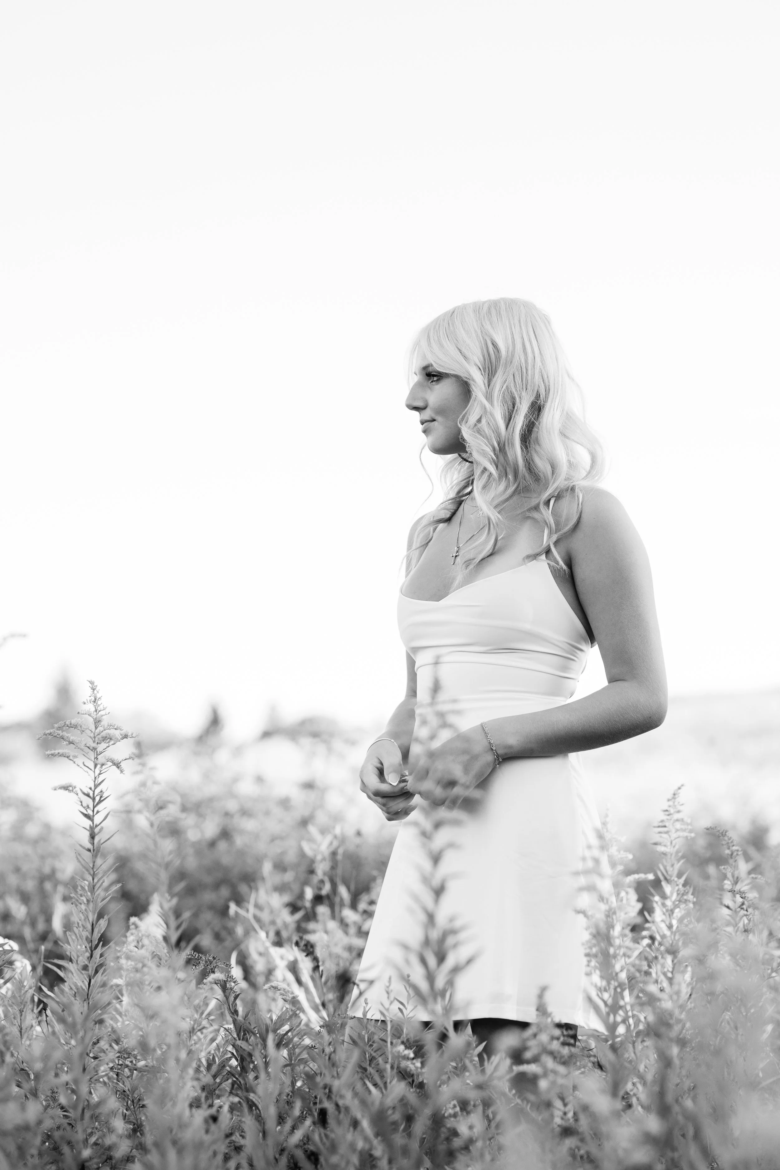 Black and white image of a beautiful girl standing in a field