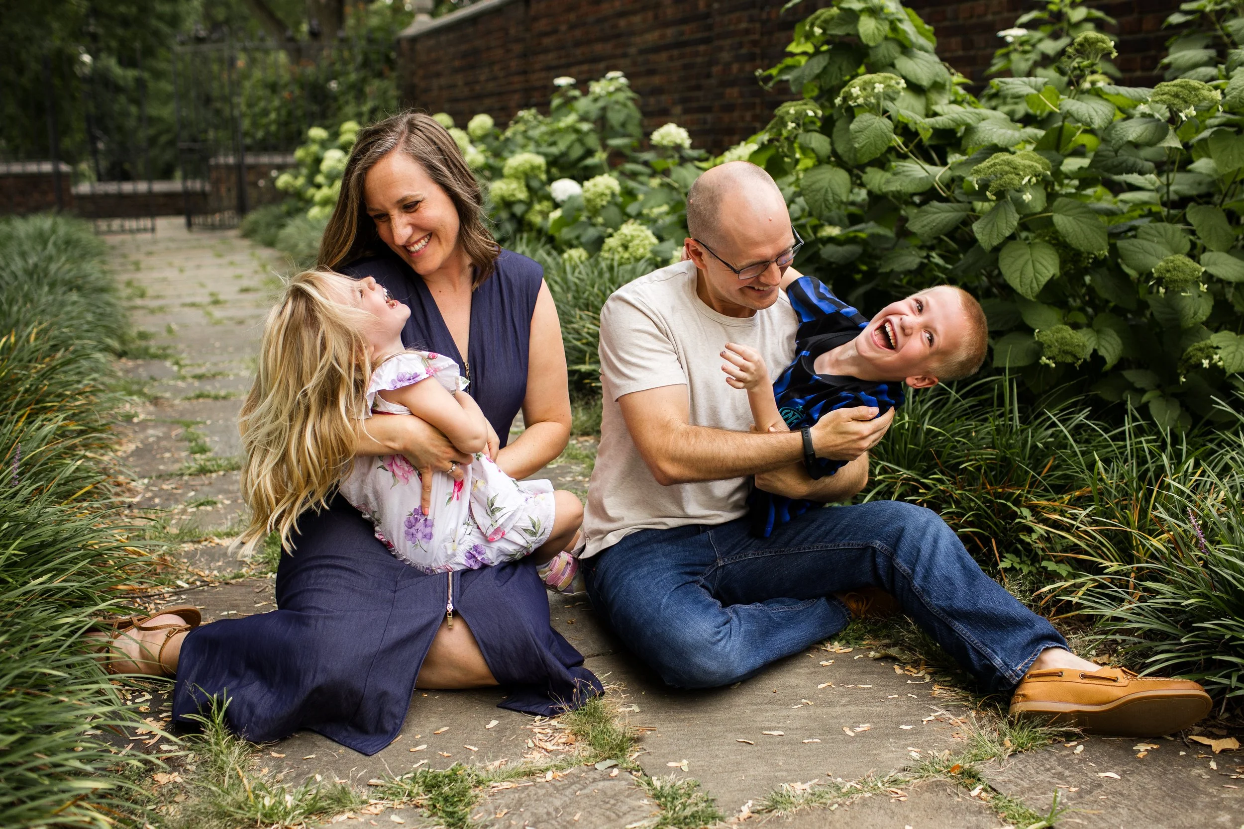 Parents share candid moment with their kids, everyone laughing after the kids surprised the parents for a photo