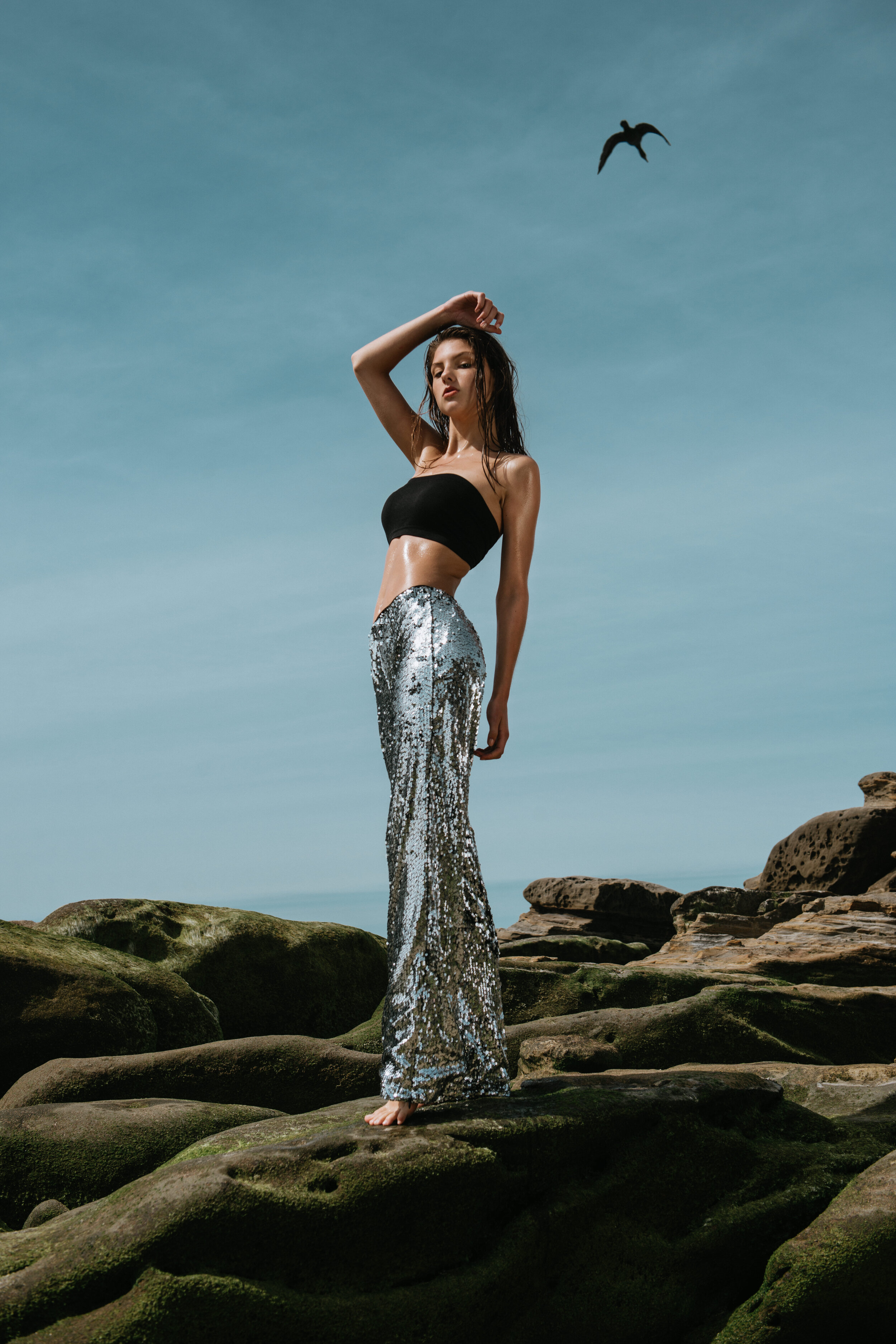  Editorial swimwear and resortwear shoot on California cliffs with model in metallic pants, styled and photographed by Kristina Yamamoto 