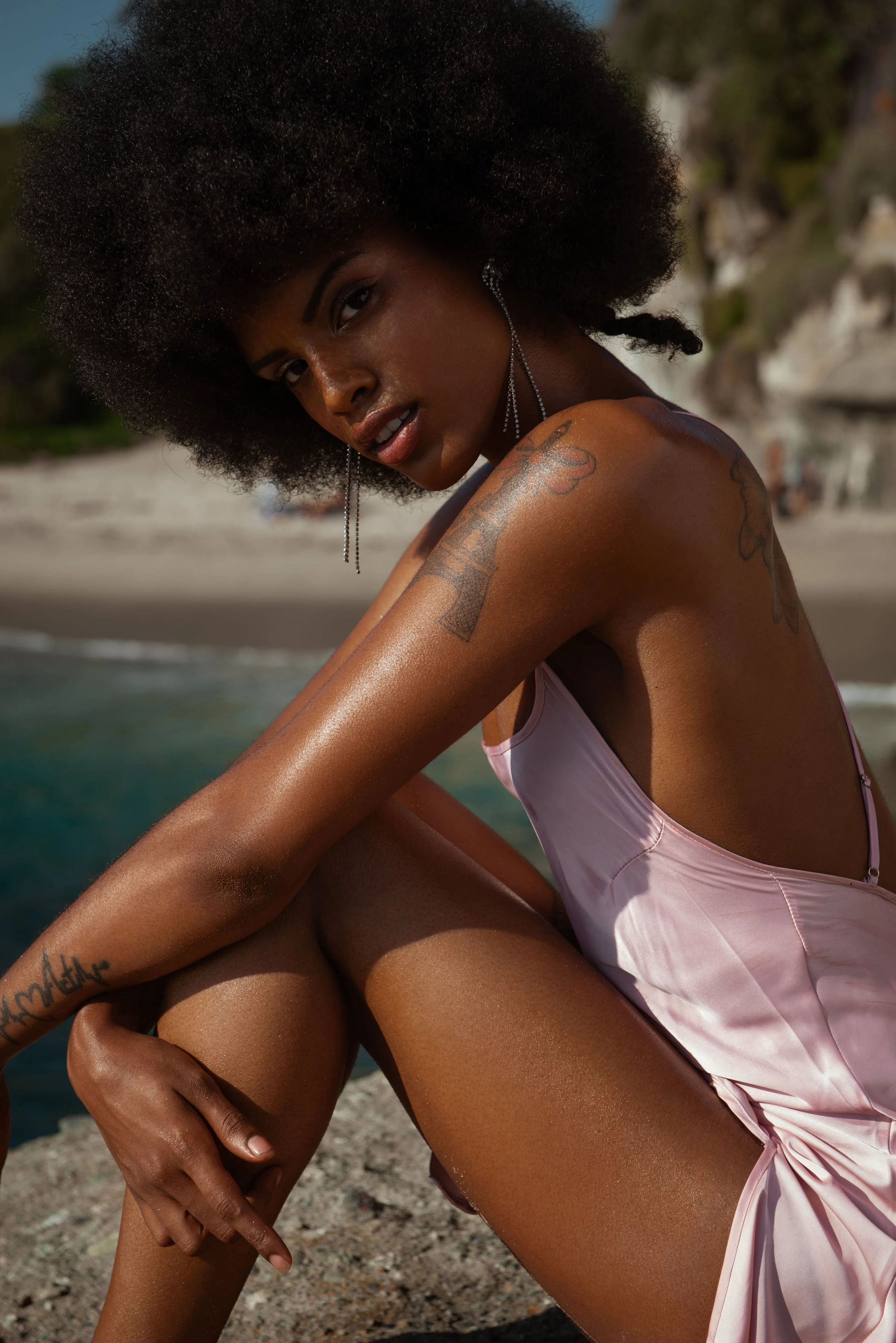  Swimwear editorial with model in blush satin swimsuit styled with bold makeup and natural texture 