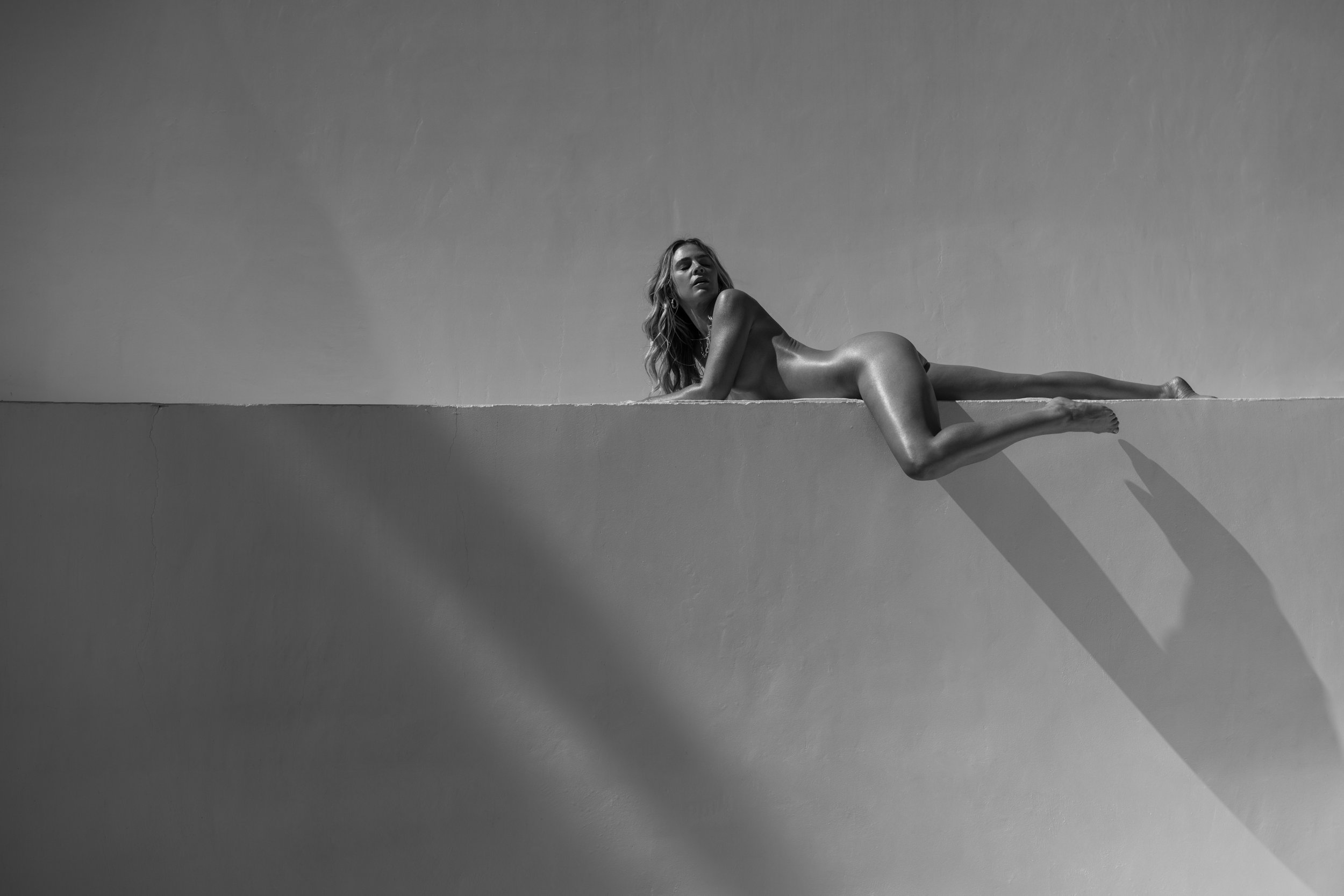  Minimalist black and white editorial with nude model posed on architectural ledge, shot by Kristina Yamamoto 