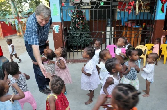 A tidal wave of toddlers surrounds John.