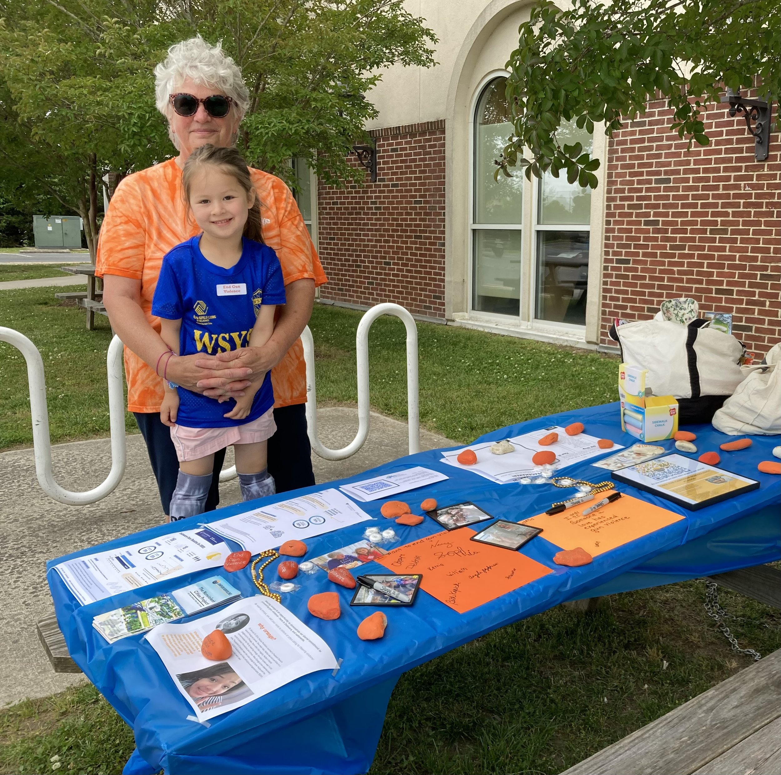 Nonviolent Seaford Coordinator Beth Kopicki tables and granddaughter table outside the Seaford District Library to raise gun safety awareness on #WearOrange Day.
