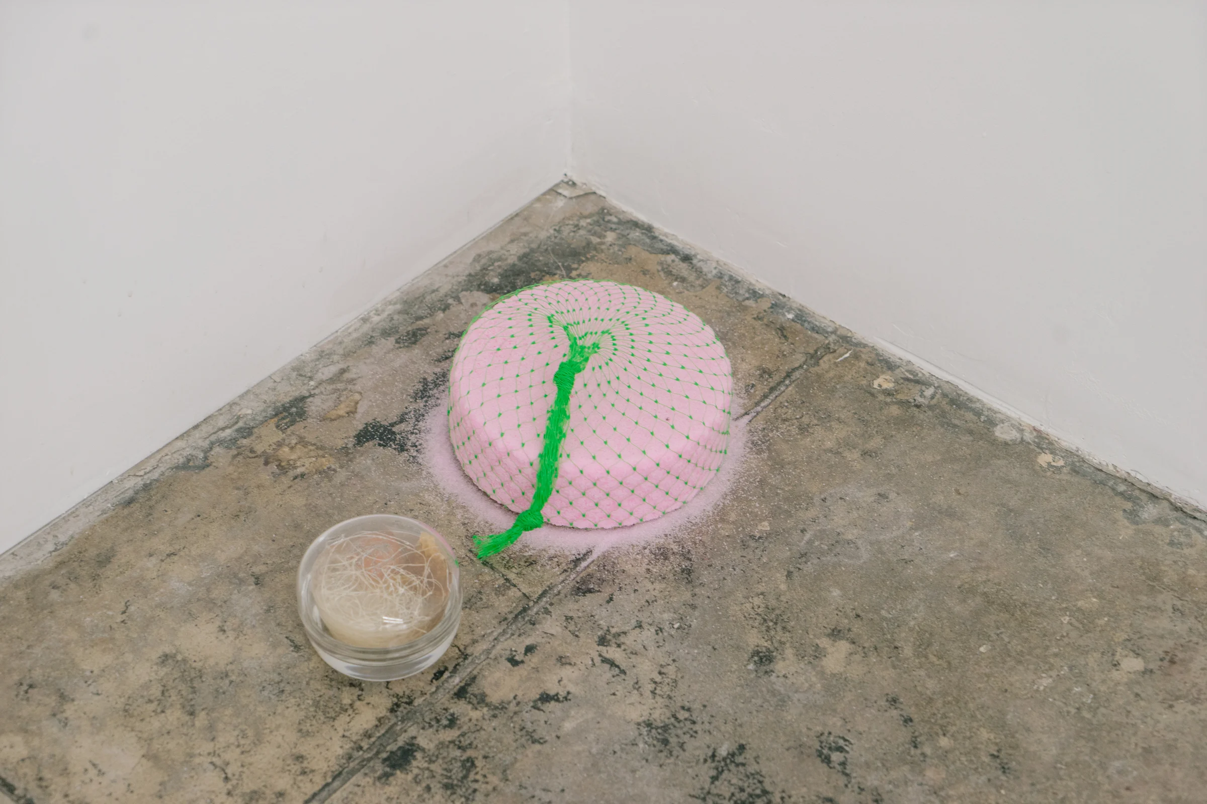 Exploring textiles as sculpture, artist Mengly Hernandez examines the role that Textile plays in temporary spaces as well as those displaced throughout the world. Textiles serve many functions, both practical and aesthetic. Connecting with community holds a place of importance with Hernandez and her work. “Cherry Block”, plastic net, fragrance block. ”Untitled”, glass container, resin, clay, chord, honeycomb, Mexican Itzel