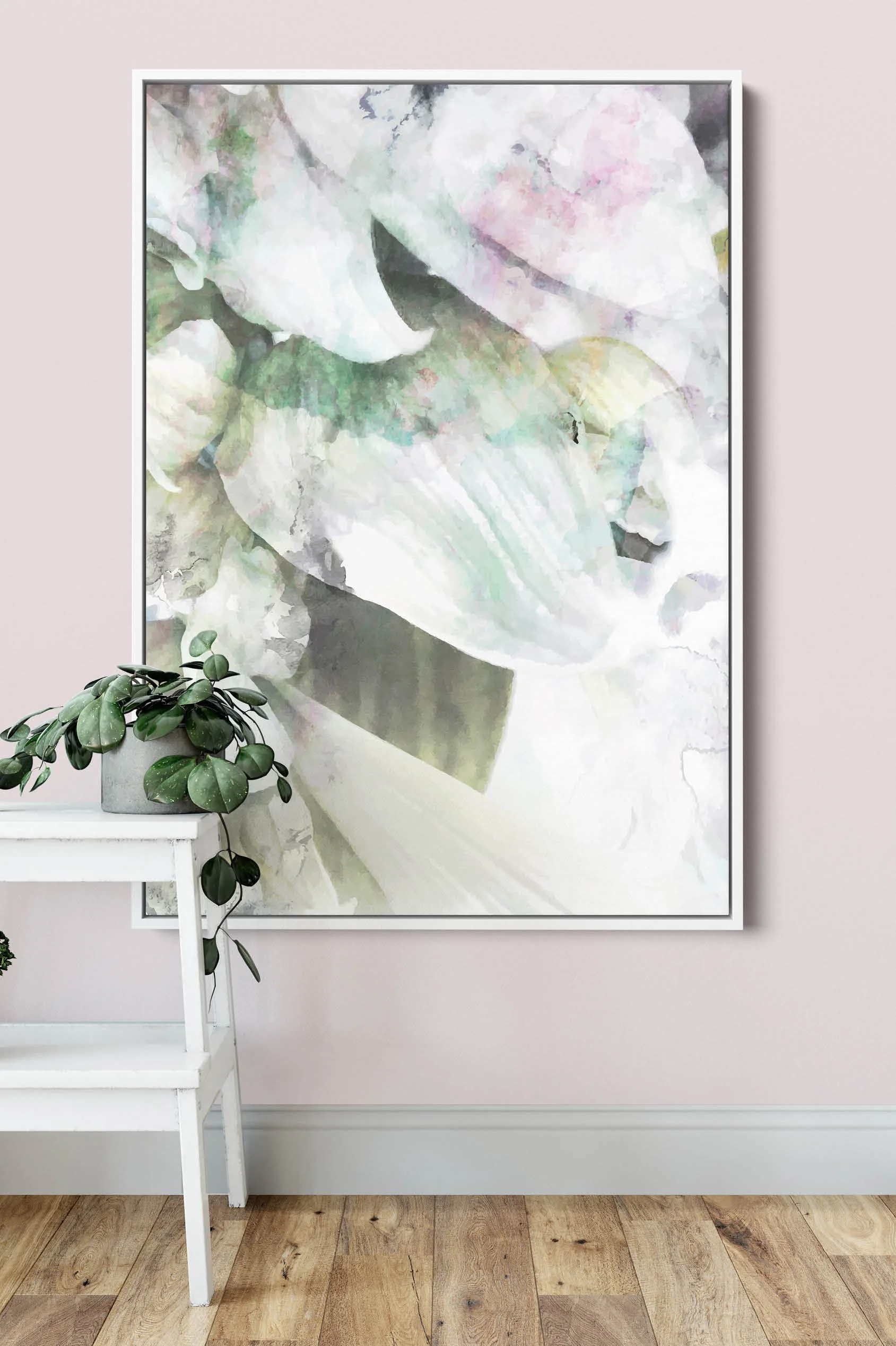 A large rectangular watercolour artwork in a white frame hangs on a pale mauve wall. The canvas print depicts abstract leaves and flower buds in hues of earthy greens with a dash of mauve.