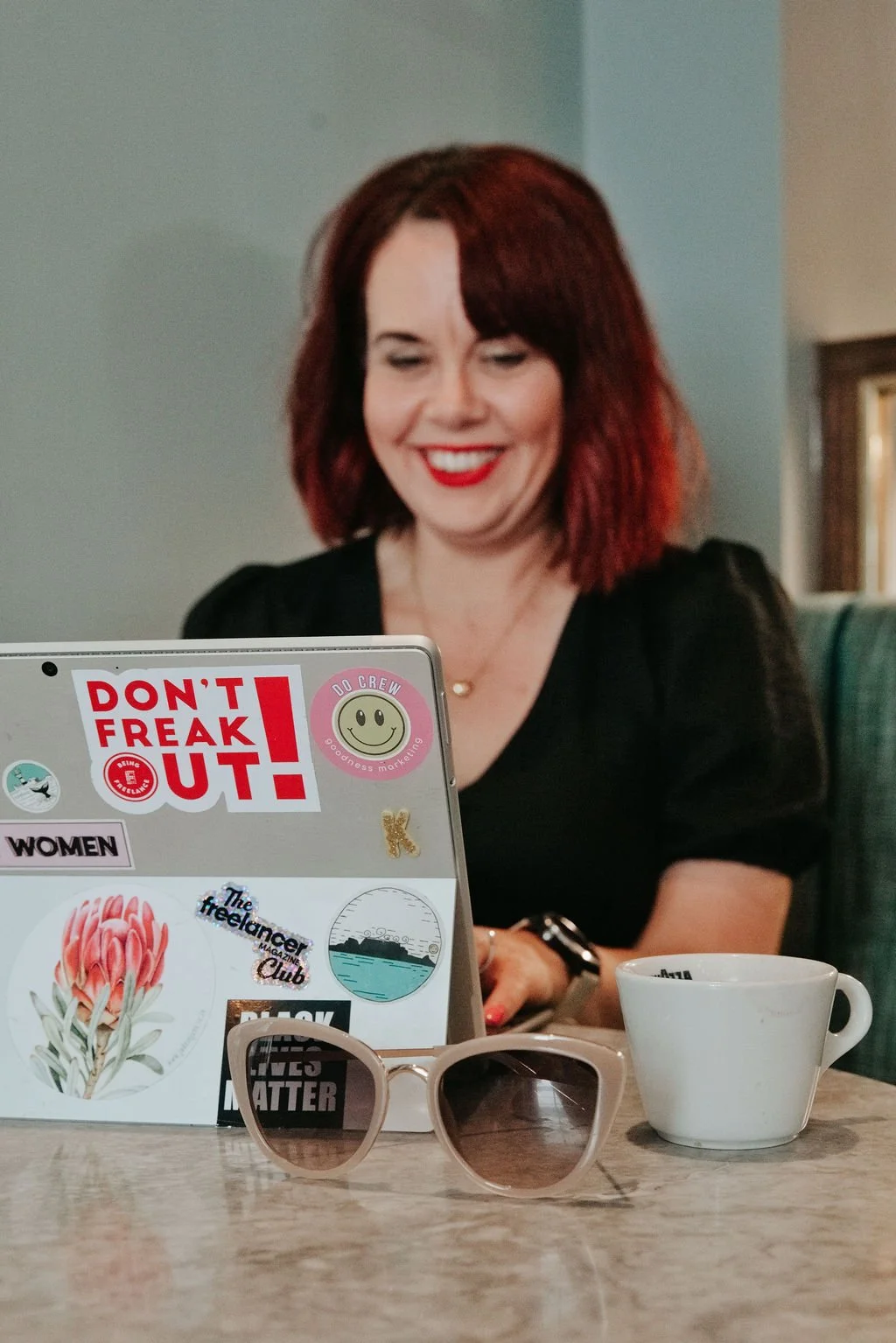 Karen Webber, marketing consultant, types on a laptop, looking delighted about it.