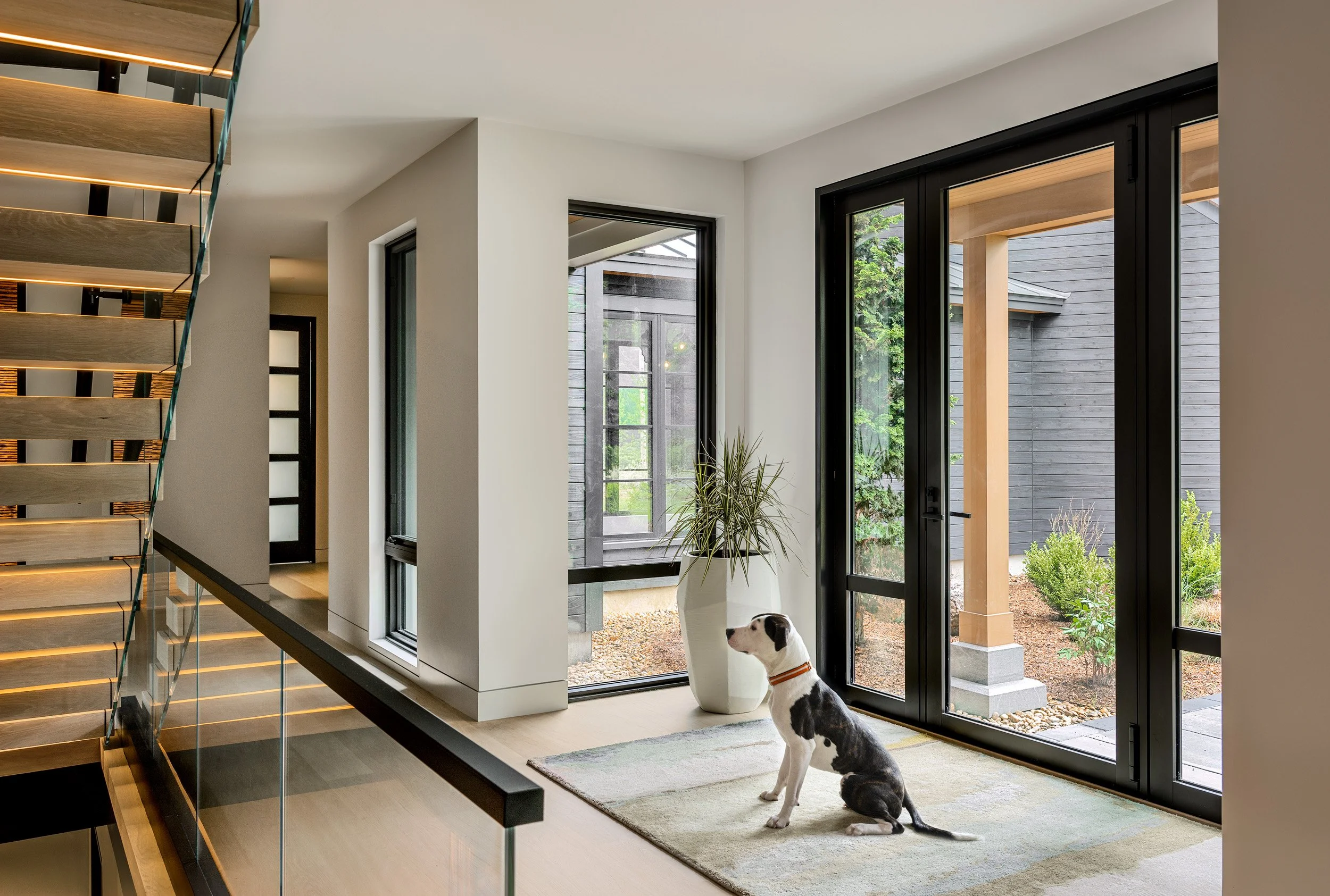 This striking contemporary residence stands elegantly positioned along a coastal marsh inlet, where its sophisticated Shou Sugi Ban treated wood siding—a traditional Japanese charring technique that creates a dramatic charcoal-black facade—establish