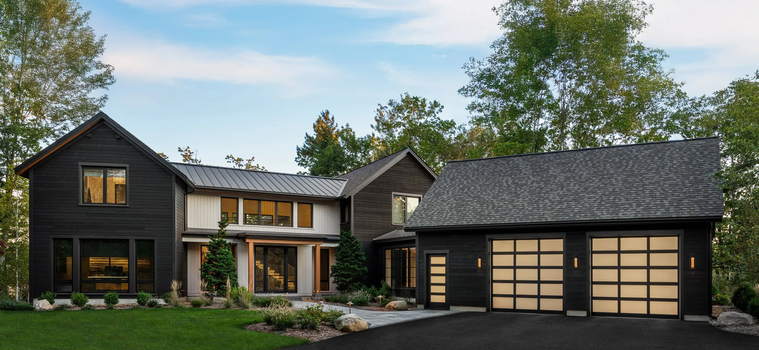  This contemporary home sits along a coastal marsh inlet and features Shou Sugi Ban treated wood siding—a Japanese charring technique that creates a dark, weather-resistant exterior. The design combines natural woods, metals, and glass to create warm