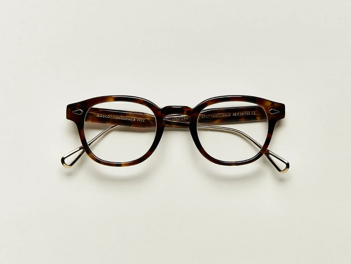 MOSCOT - Lemtosh-TT SE Opticals £310 COLOUR Tortoise/ Gold SIZE 46 When Hyman arrived on Ellis Island 119 years ago, he heard, "What is your name, where are you from?" shouted from a distance. Although the ground was not paved in gold as promised, we wanted to honor his ambitious thinking by launching a Special Edition of the treasured LEMTOSH. Handcrafted using a combination of metal and Italian acetate featuring unique patterns distinctive to each frame Features diamond rivets Comfortable key hole nose bridge Includes acetate nose pads 7-Barrel hinge MOSCOT temple engravings Exclusive gold titanium temple tips
