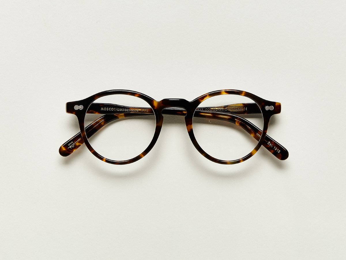 MOSCOT - Militzen Opticals £245 COLOUR Classic Havana SIZE 49 The round, full-vue MILTZEN, first introduced in the 1930s, is eponymously named for our Uncle Heshy, who inexplicably everyone called Uncle Miltzen. And it stuck. So there you go, world... The MILTZEN. Handcrafted using Italian acetate Features adjoined dot rivets Comfortable key hole nose bridge Includes acetate nose pads 3-Barrel hinge MOSCOT temple engravings