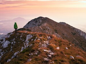 Woman on mountain at sunset representing OpenLearn by the Open University free environmental courses