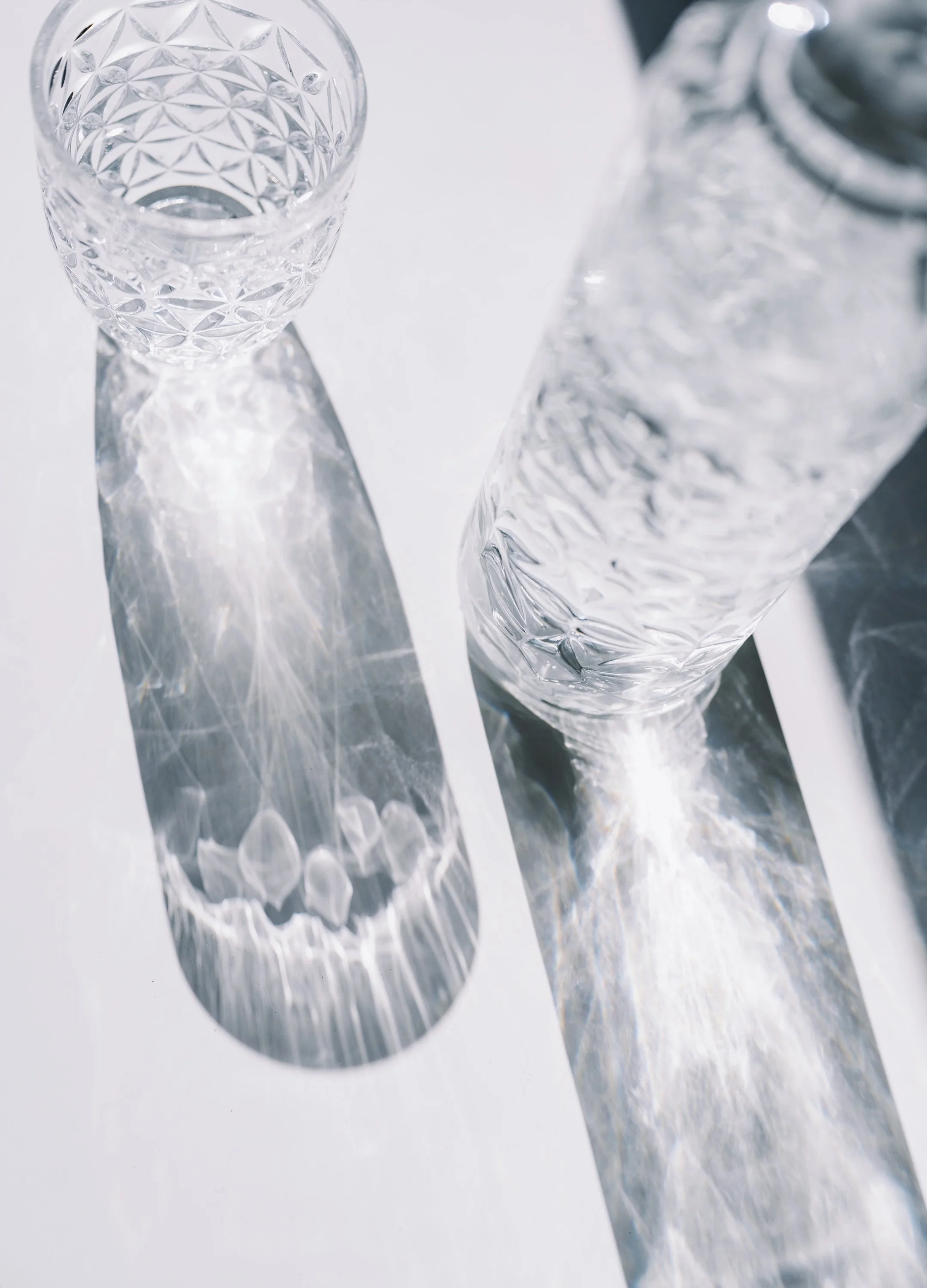 Cut-glass tumblers catching soft light, representing clarity, reflection, and refined next steps for a brand.
