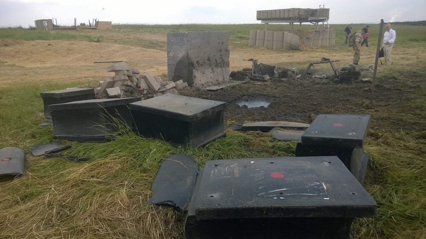 ProtectiFlex is the only wall left standing after the 5kg charge is detonated. Competitor wall system lying in the foreground Glazing system and concrete wall.