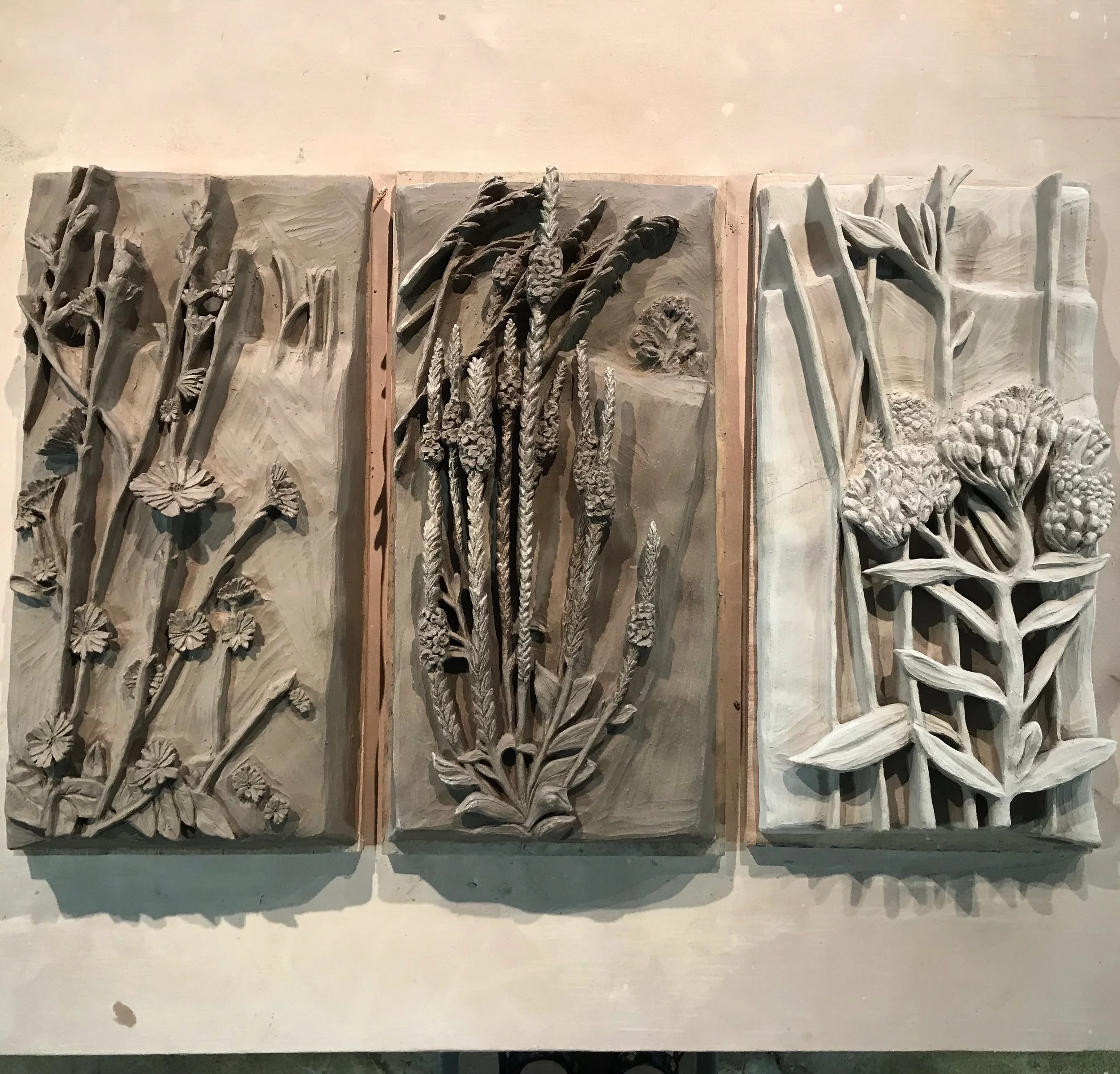 Ceramic wildflowers in different stages of drying.