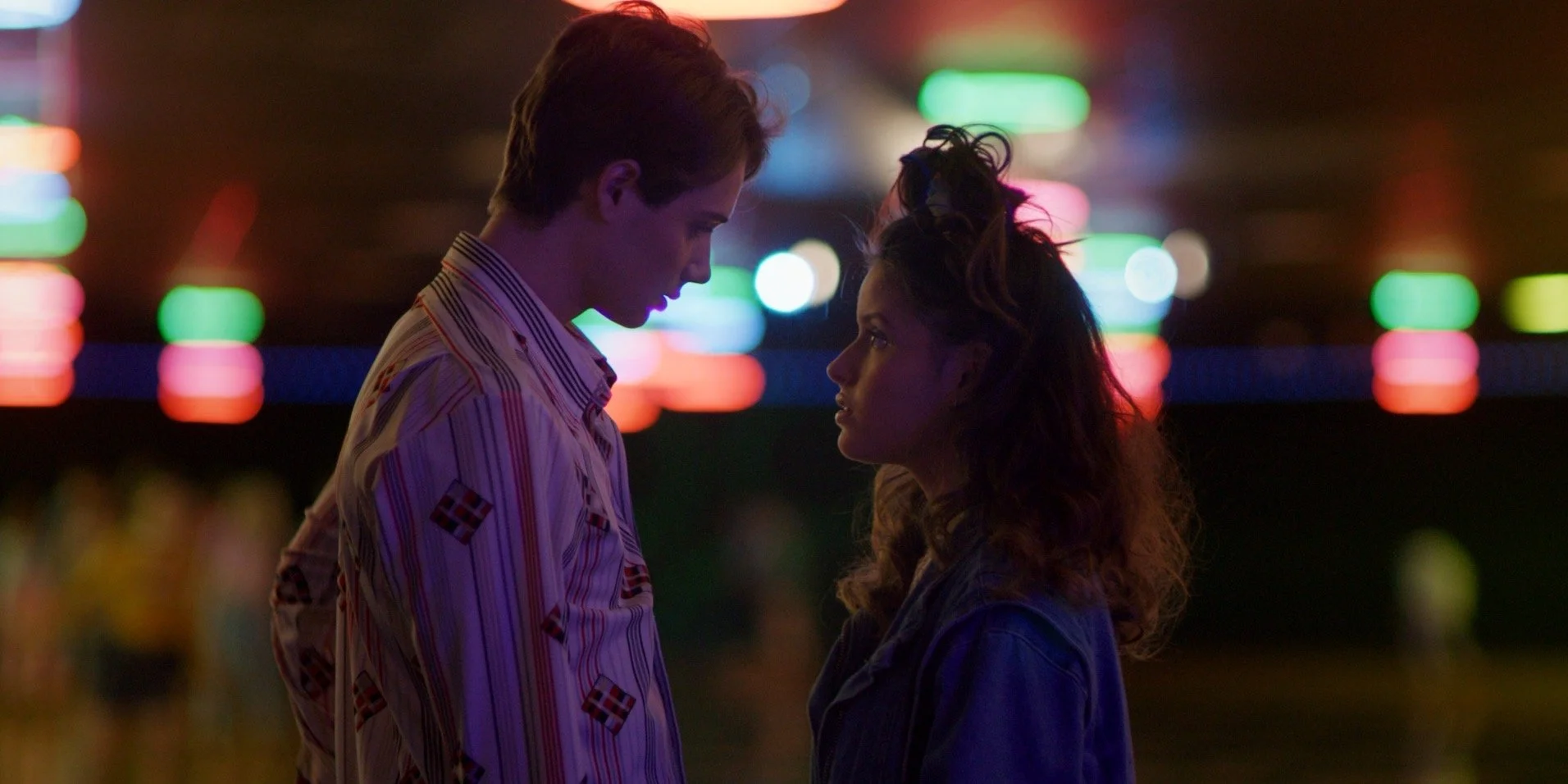 Couple at neon-lit carnival in Going Viral narrative feature film