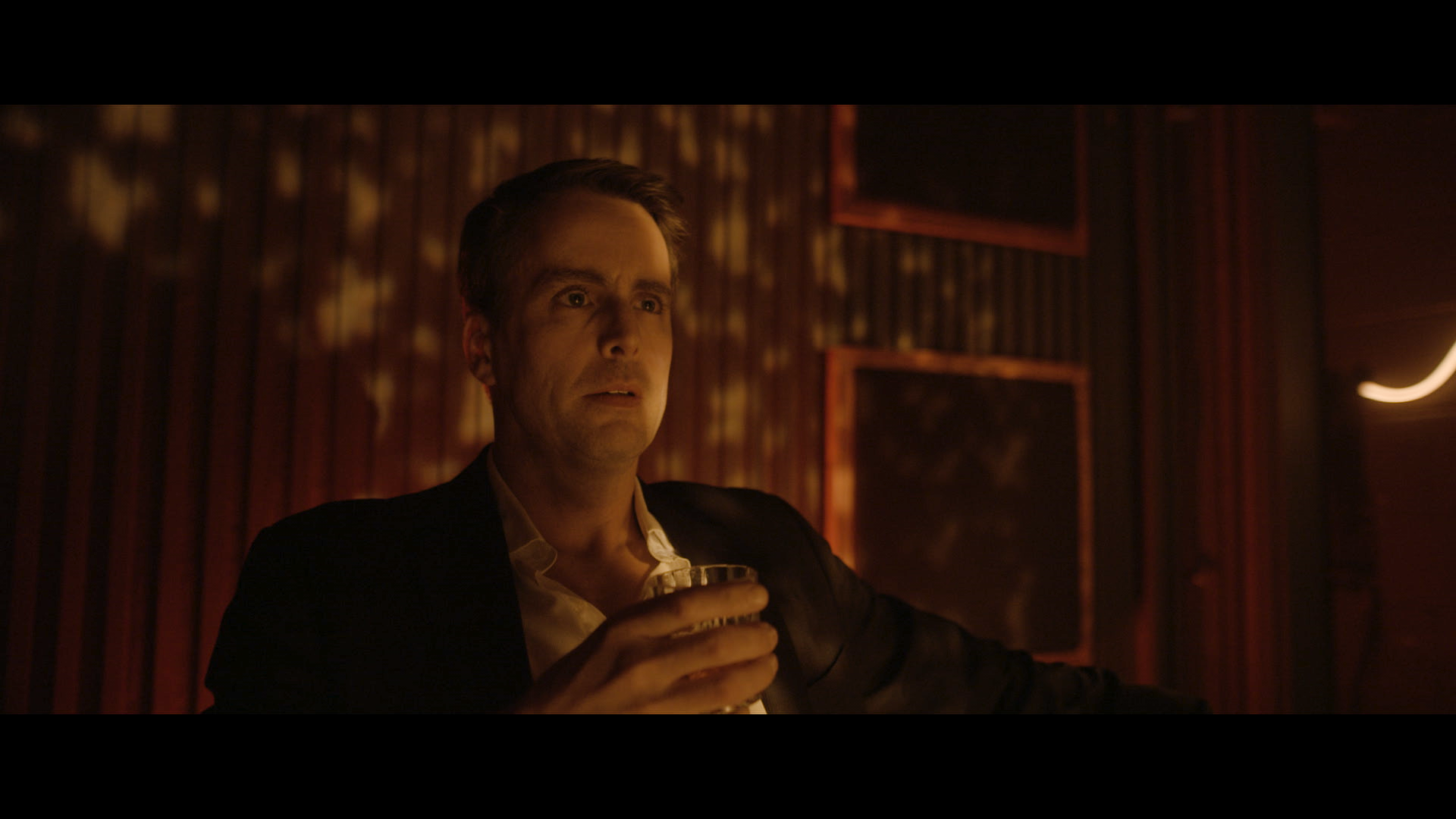 Still from Paid for By narrative short film - man in moody interior lighting