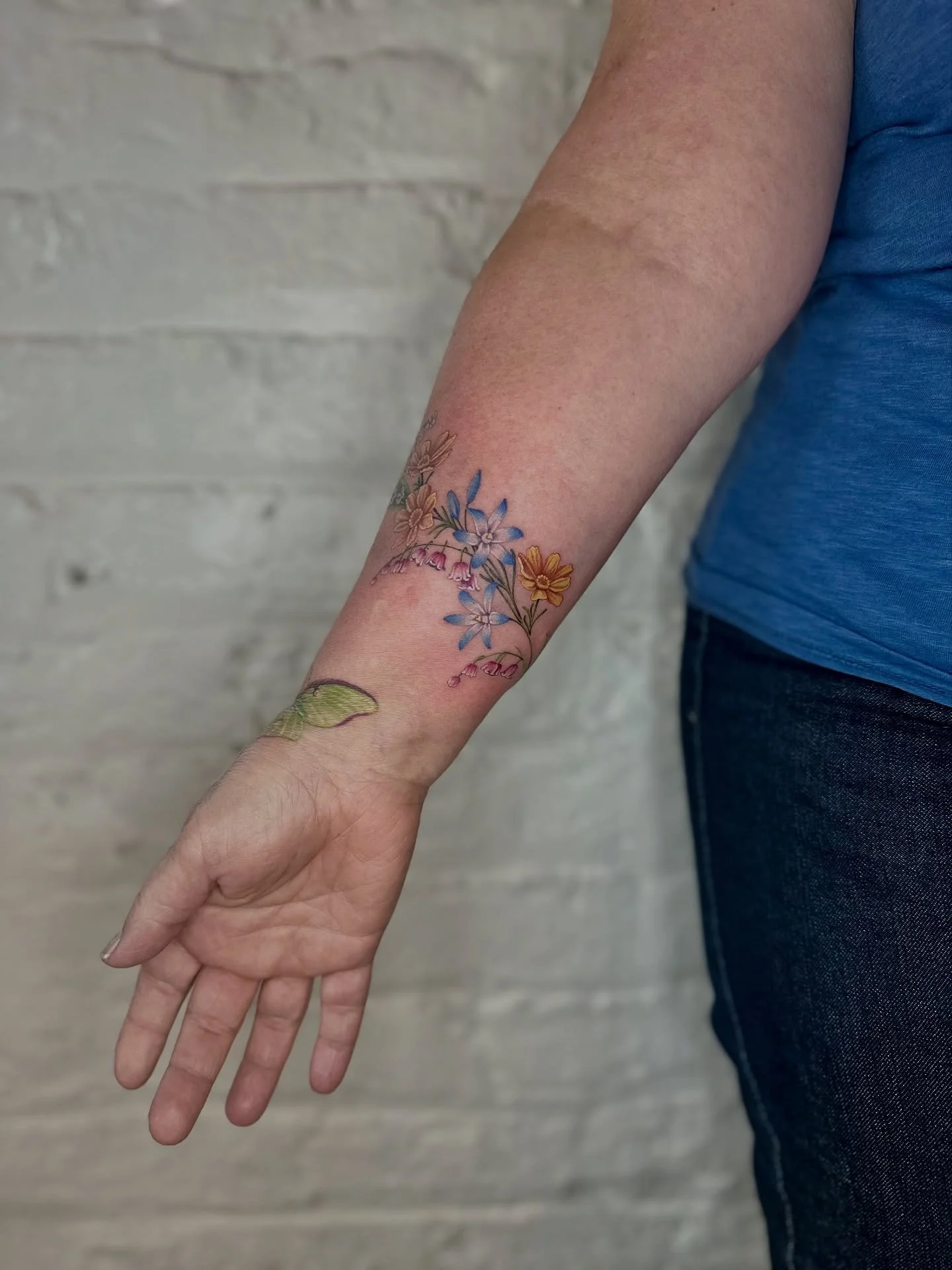 ✨Wrap tattoos are so incredibly hard to capture &mdash; what angle do you even choose? What pose best shows off the flow of the piece? How do you think I did? 👀

This design features glory of the snow, pink lily of the valley, prairie coreopsis, and