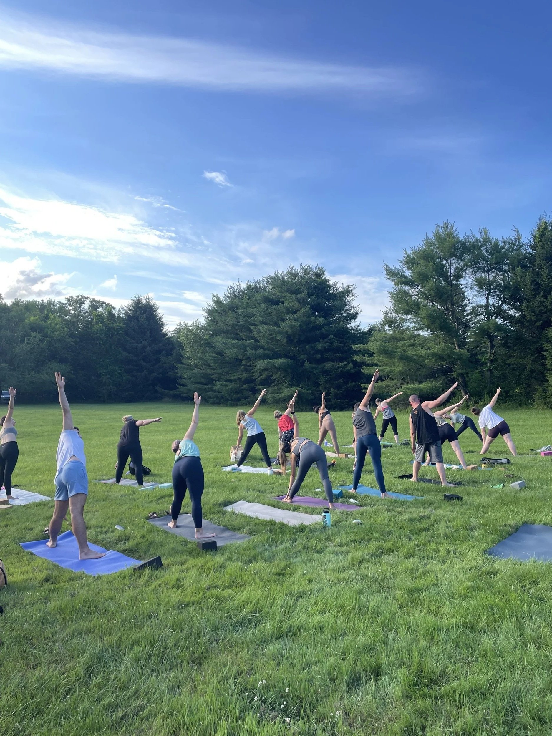 A group of students doing yoga outside on the lawn at Revive in Berwick, ME