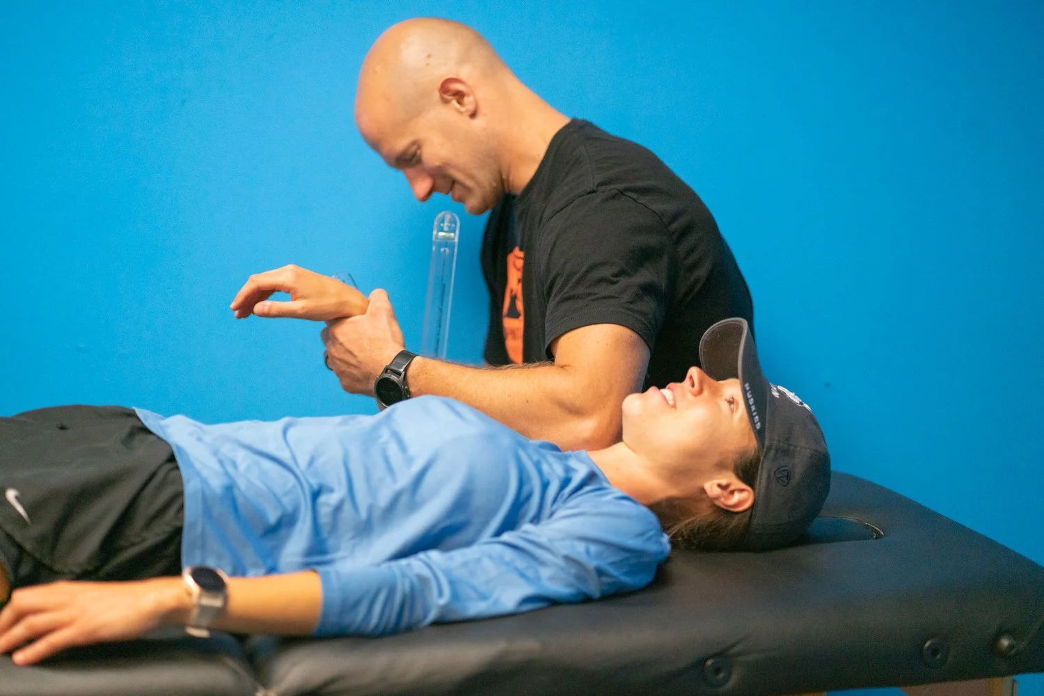 Doctor of physical therapy assessing a client's shoulder in South Portland, Maine.